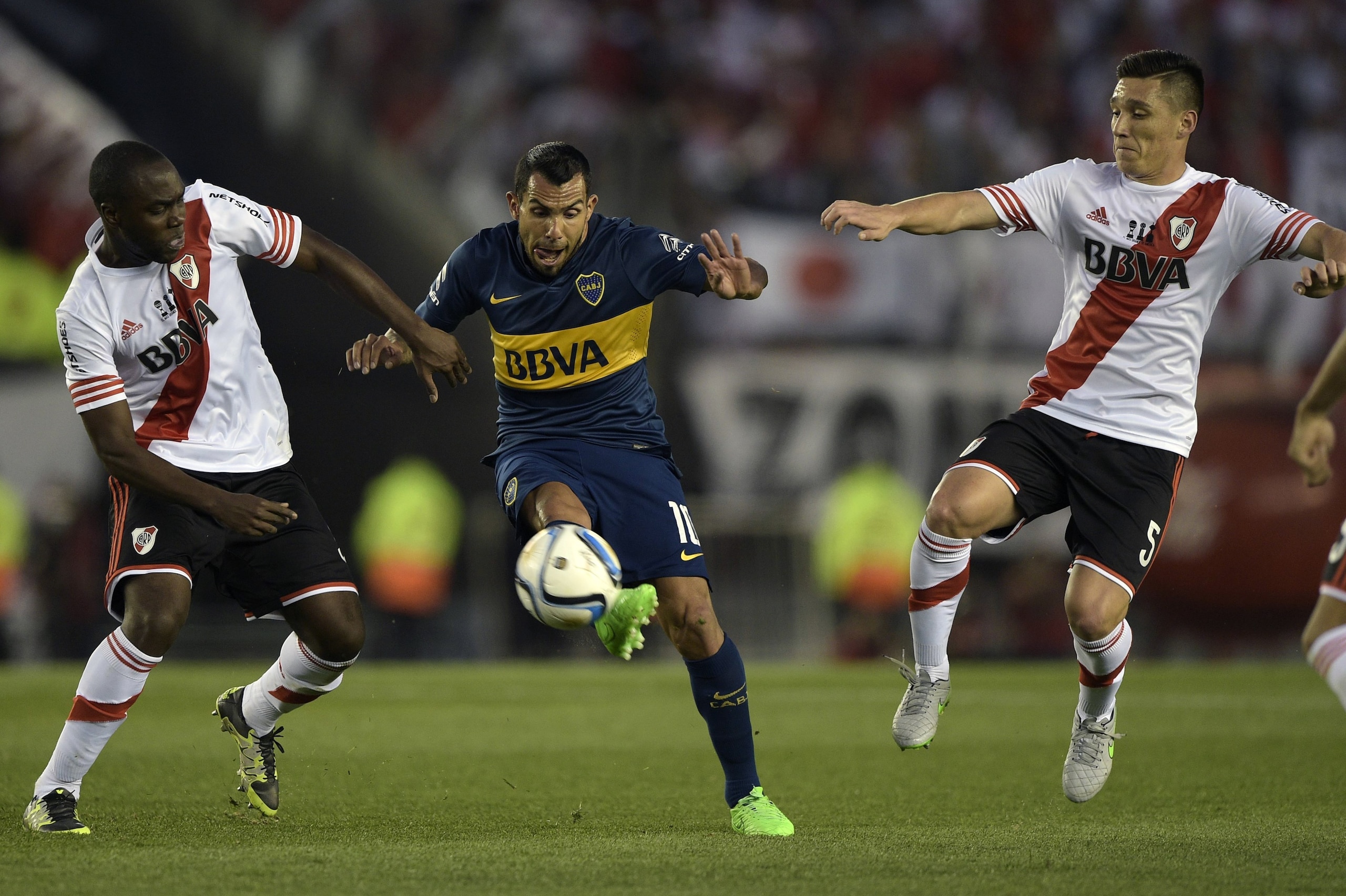 Boca Juniors' forward Carlos Tevez (C) vies for the ball with River Plate's defender Eder Alvarez Balanta (L) and midfielder Matias Kranevitter during their Argentine first division football match at the Monumental stadium in Buenos Aires, Argentina, on S Boca Juniors' forward Carlos Tevez (C) vies for the ball with River Plate's defender Eder Alvarez Balanta (L) and midfielder Matias Kranevitter during their Argentine first division football match at the Monumental stadium in Buenos Aires, Argentina, on S