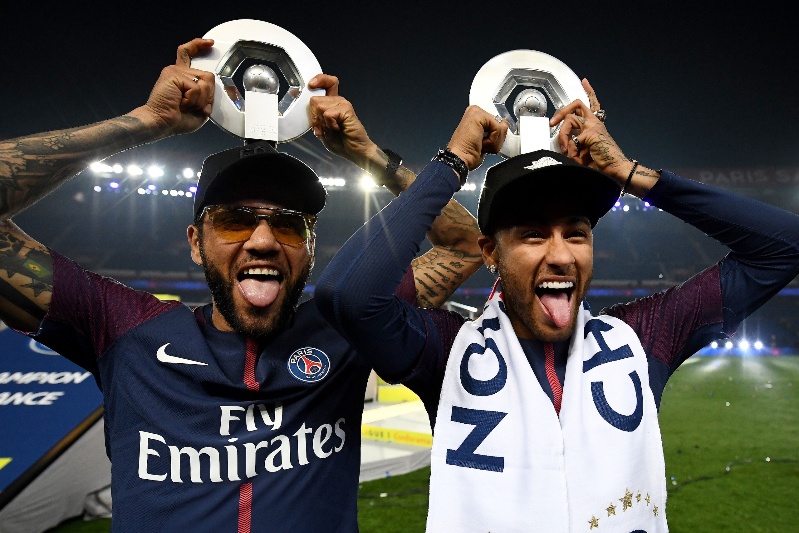 Paris Saint-Germain's Brazilian defender Dani Alves (L) and Paris Saint-Germain's Brazilian forward Neymar joke after winning the French L1 title at the end of the French L1 football match Paris Saint-Germain (PSG) vs Rennes on May 12, 2018 at the Parc de