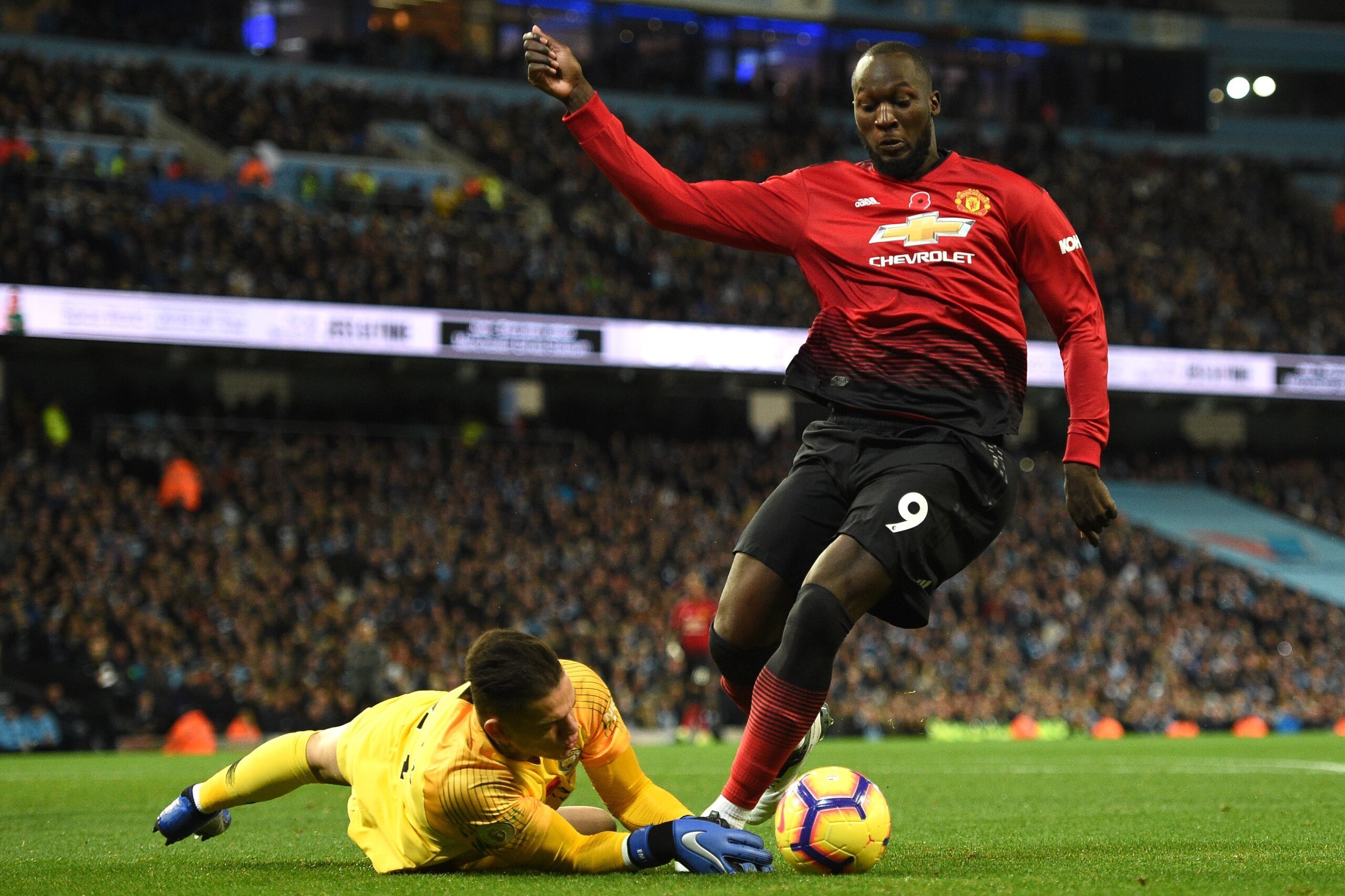 Manchester City's Brazilian goalkeeper Ederson tackles Manchester United's Belgian striker Romelu Lukaku to give away a penalty during the English Premier League football match between Manchester City and Manchester United at the Etihad Stadium in Manches