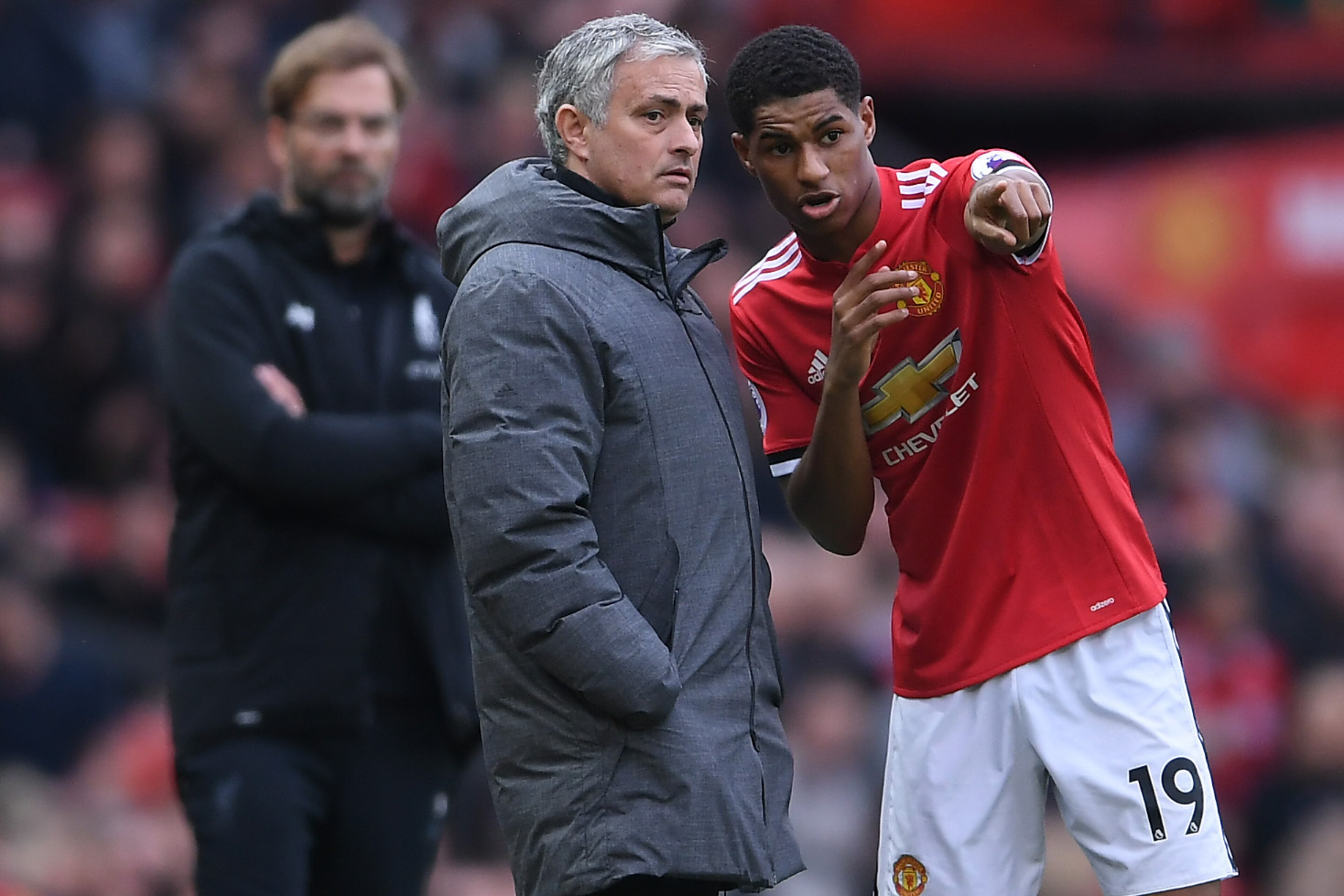 MANCHESTER, ENGLAND - MARCH 10: Jose Mourinho of Manchester United speaks to Marcus Rashford as Jurgen Klopp of Liverpool looks on during the Premier League match between Manchester United and Liverpool at Old Trafford on March 10, 2018 in Manchester, En MANCHESTER, ENGLAND - MARCH 10: Jose Mourinho of Manchester United speaks to Marcus Rashford as Jurgen Klopp of Liverpool looks on during the Premier League match between Manchester United and Liverpool at Old Trafford on March 10, 2018 in Manchester, En