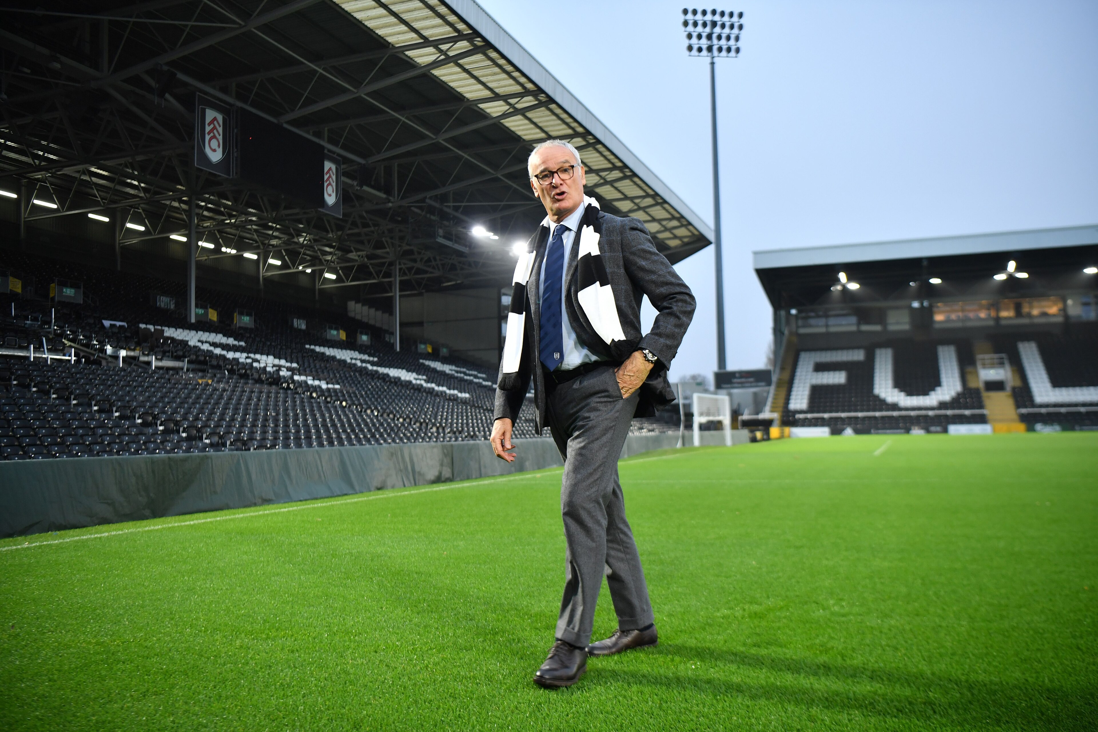 Fulham's new Italian manager Claudio Ranieri poses with a team scarf on the pitch at the club's Craven Cottage stadium on November 16, 2018. (Photo by BEN STANSALL / AFP) / RESTRICTED TO EDITORIAL USE. No use with unauthorized audio, video, data, fixture 