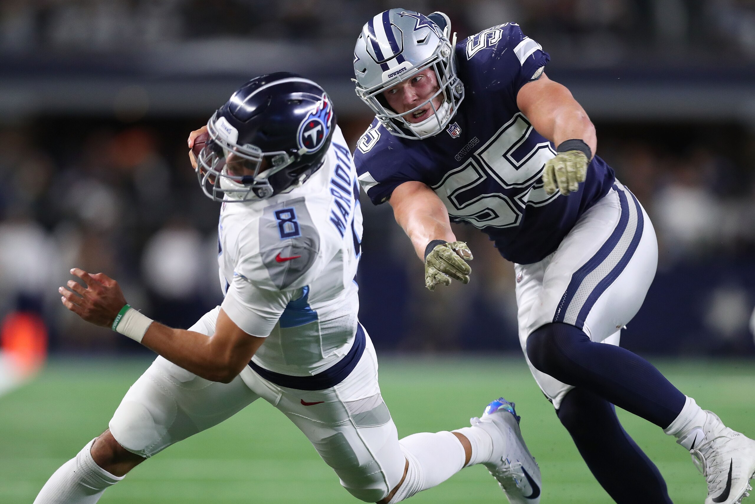 ARLINGTON, TX - NOVEMBER 05:  Marcus Mariota #8 of the Tennessee Titans is pursued byLeighton Vander Esch #55 of the Dallas Cowboys in the fourth quarter of a football game at AT&T Stadium on November 5, 2018 in Arlington, Texas.  (Photo by Tom Pennington