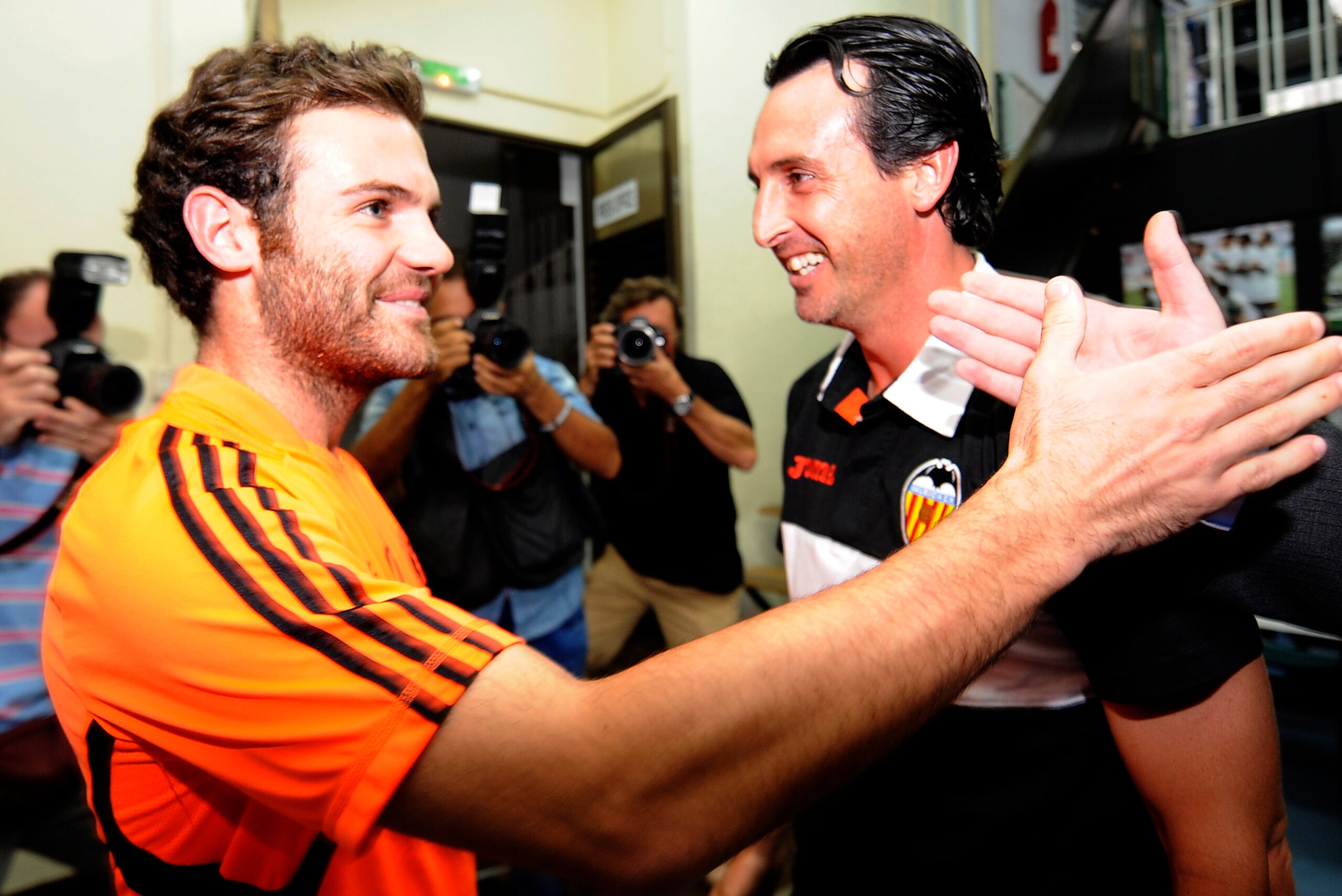 Valencia's coach Unai Emery (R) greets Chelsea's Spanish forward Juan Mata during a press conference at the Mestalla Stadium in Valencial on September 27, 2011 on the eve of the UEFA Champions League football match between Valencia and  Chelsea. AFP PHOTO