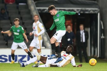MILTON KEYNES, ENGLAND - NOVEMBER 13: Aaron Connolly of Brighton & Hove Albion U21 rides the tackle of Ousseynou Cisse of Milton Keynes Dons during the Checkatrade Trophy match between Milton Keynes Dons and  Brighton & Hove Albion U21   at Stadium mk on 