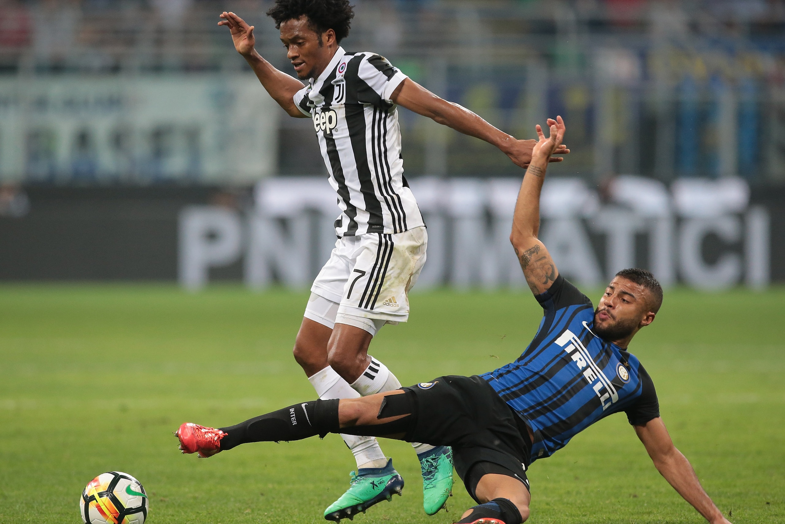 MILAN, ITALY - APRIL 28:  Juan Cuadrado (L) of Juventus FC competes for the ball with Rafinha Alcantara of FC Internazionale Milano during the serie A match between FC Internazionale and Juventus at Stadio Giuseppe Meazza on April 28, 2018 in Milan, Italy