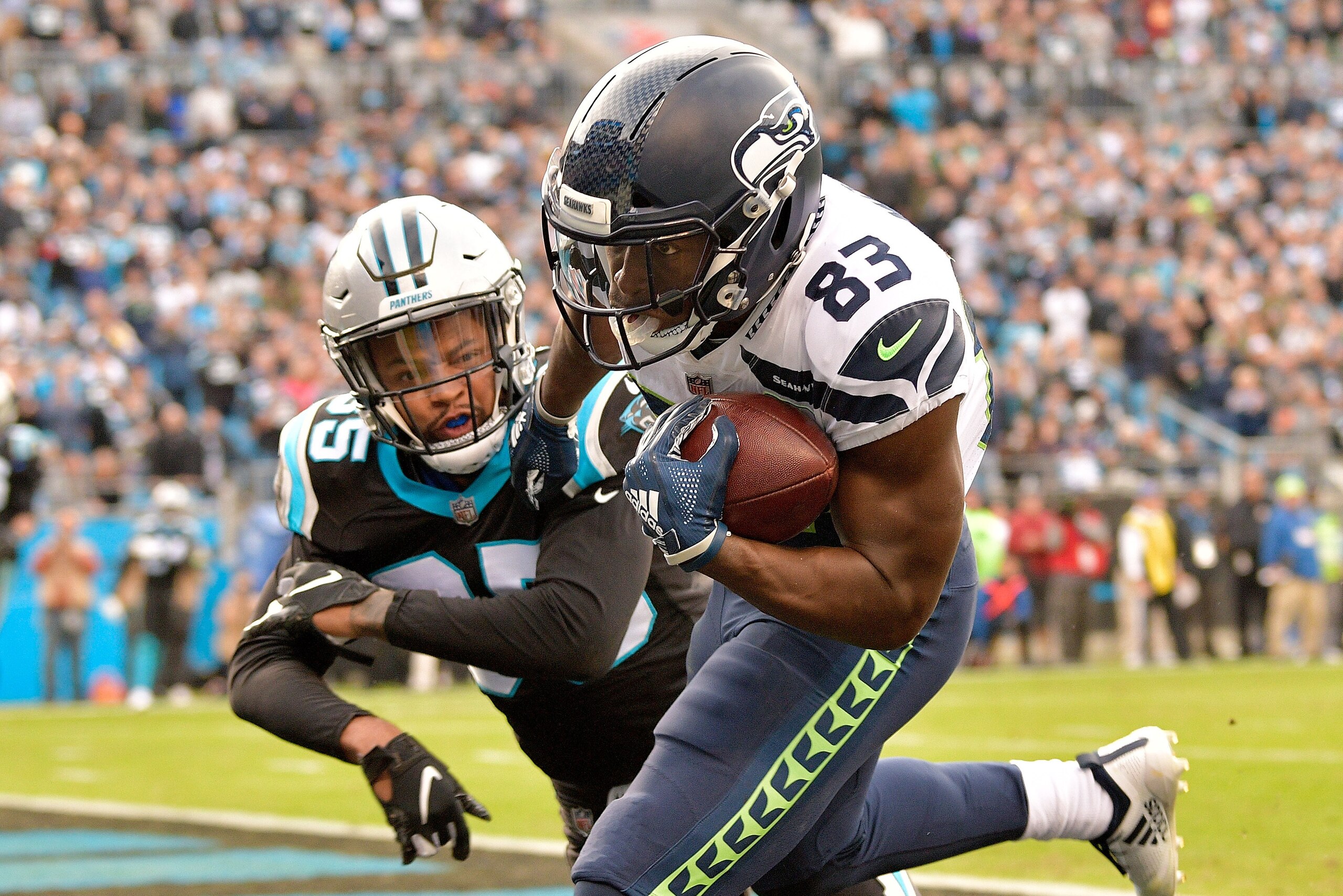 CHARLOTTE, NC - NOVEMBER 25: David Moore #83 of the Seattle Seahawks makes the game-tying touchdown catch against Corn Elder #35 of the Carolina Panthers during the fourth quarter of their game at Bank of America Stadium on November 25, 2018 in Charlotte CHARLOTTE, NC - NOVEMBER 25: David Moore #83 of the Seattle Seahawks makes the game-tying touchdown catch against Corn Elder #35 of the Carolina Panthers during the fourth quarter of their game at Bank of America Stadium on November 25, 2018 in Charlotte