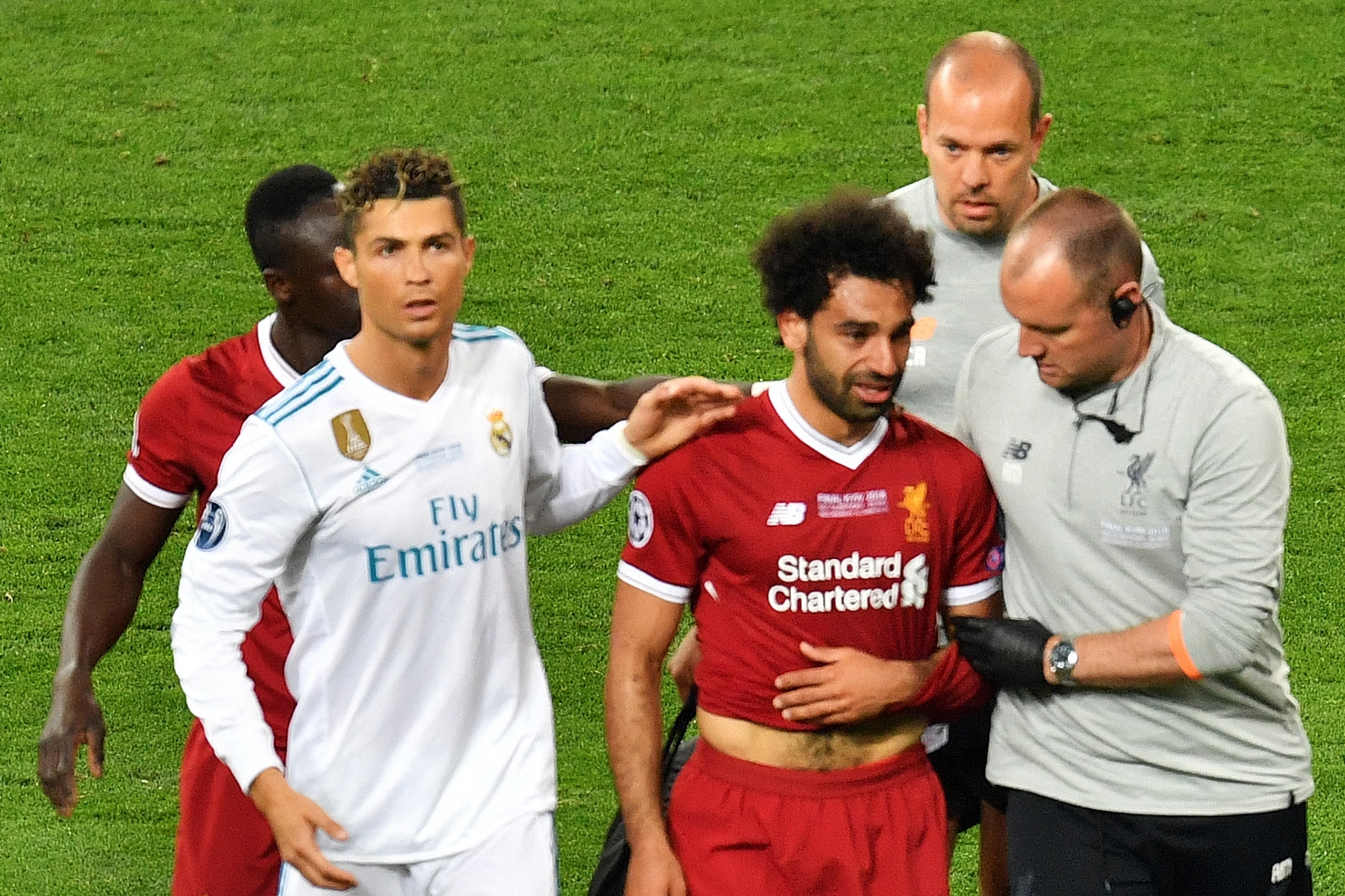 Liverpool's Egyptian forward Mohamed Salah (3rd R) is comforted by team members and Real Madrid's Portuguese forward Cristiano Ronaldo (2nd L) as he leaves the pitch after injury during the UEFA Champions League final football match between Liverpool and Liverpool's Egyptian forward Mohamed Salah (3rd R) is comforted by team members and Real Madrid's Portuguese forward Cristiano Ronaldo (2nd L) as he leaves the pitch after injury during the UEFA Champions League final football match between Liverpool and