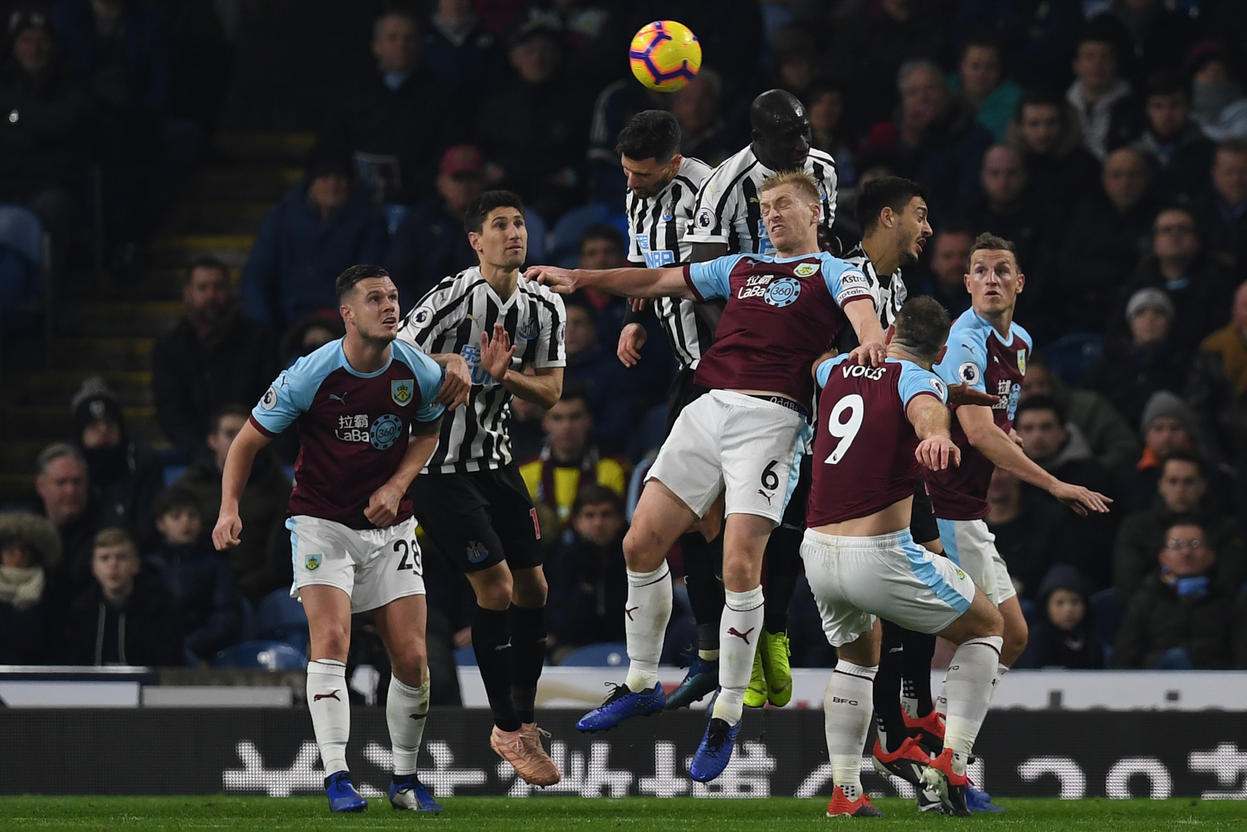Burnley's English defender Ben Mee (C) jumps to head the ball during the English Premier League football match between Burnley and Newcastle United at Turf Moor in Burnley, north west England on November 26, 2018. (Photo by Paul ELLIS / AFP) / RESTRICTED 