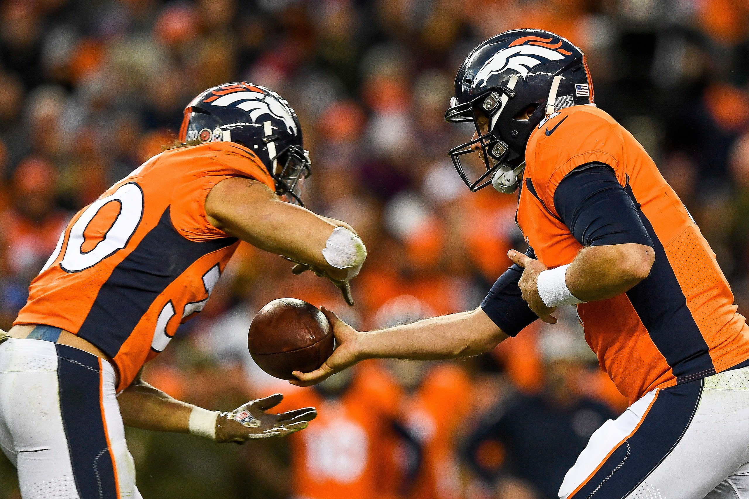 DENVER, CO - NOVEMBER 4:  Quarterback Case Keenum #4 hands the ball to running back Phillip Lindsay #30 of the Denver Broncos in the fourth quarter of a game at Broncos Stadium at Mile High on November 4, 2018 in Denver, Colorado. (Photo by Dustin Bradfor