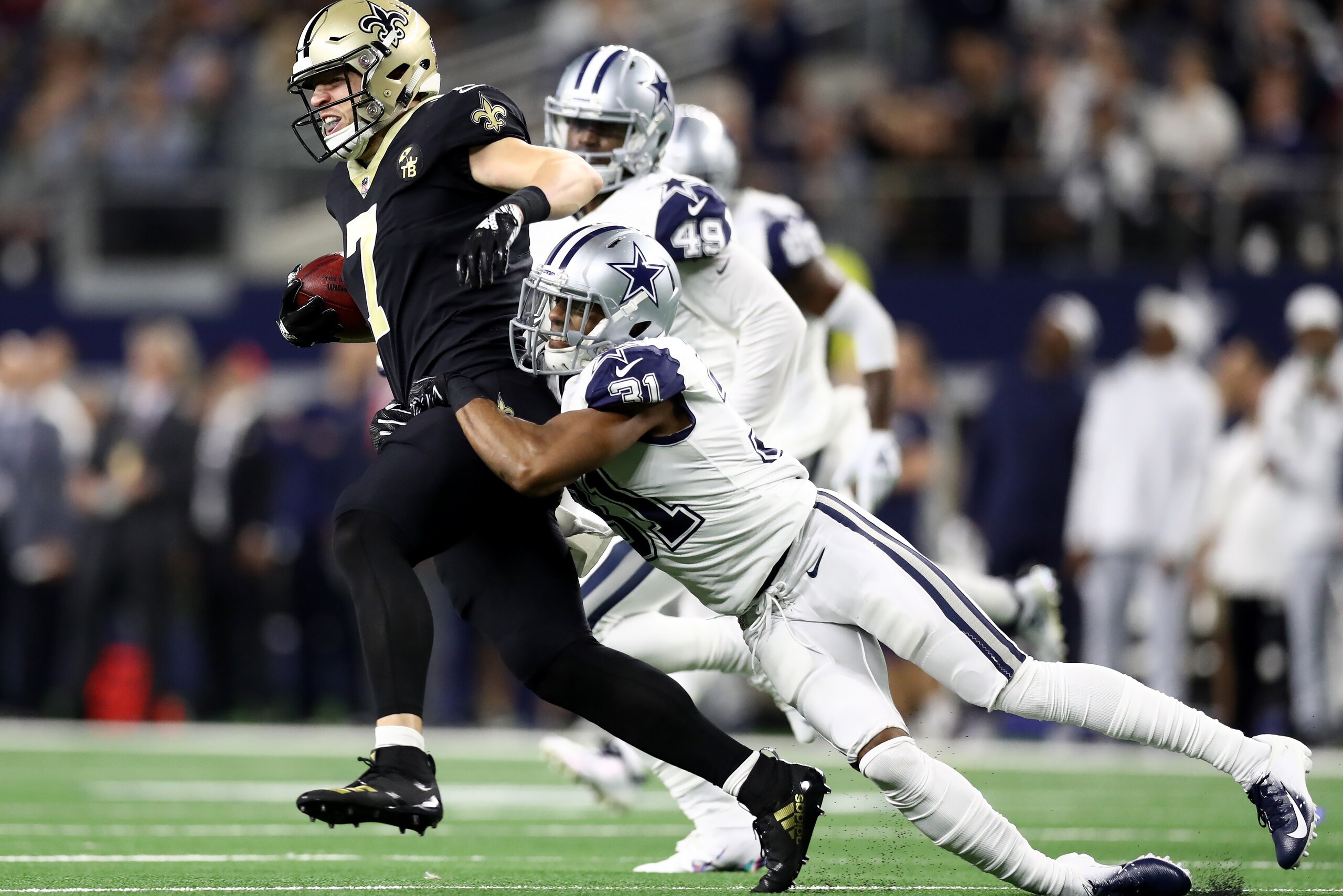 ARLINGTON, TEXAS - NOVEMBER 29:  Taysom Hill #7 of the New Orleans Saints is tackled by Byron Jones #31 of the Dallas Cowboys at AT&T Stadium on November 29, 2018 in Arlington, Texas. (Photo by Ronald Martinez/Getty Images)
