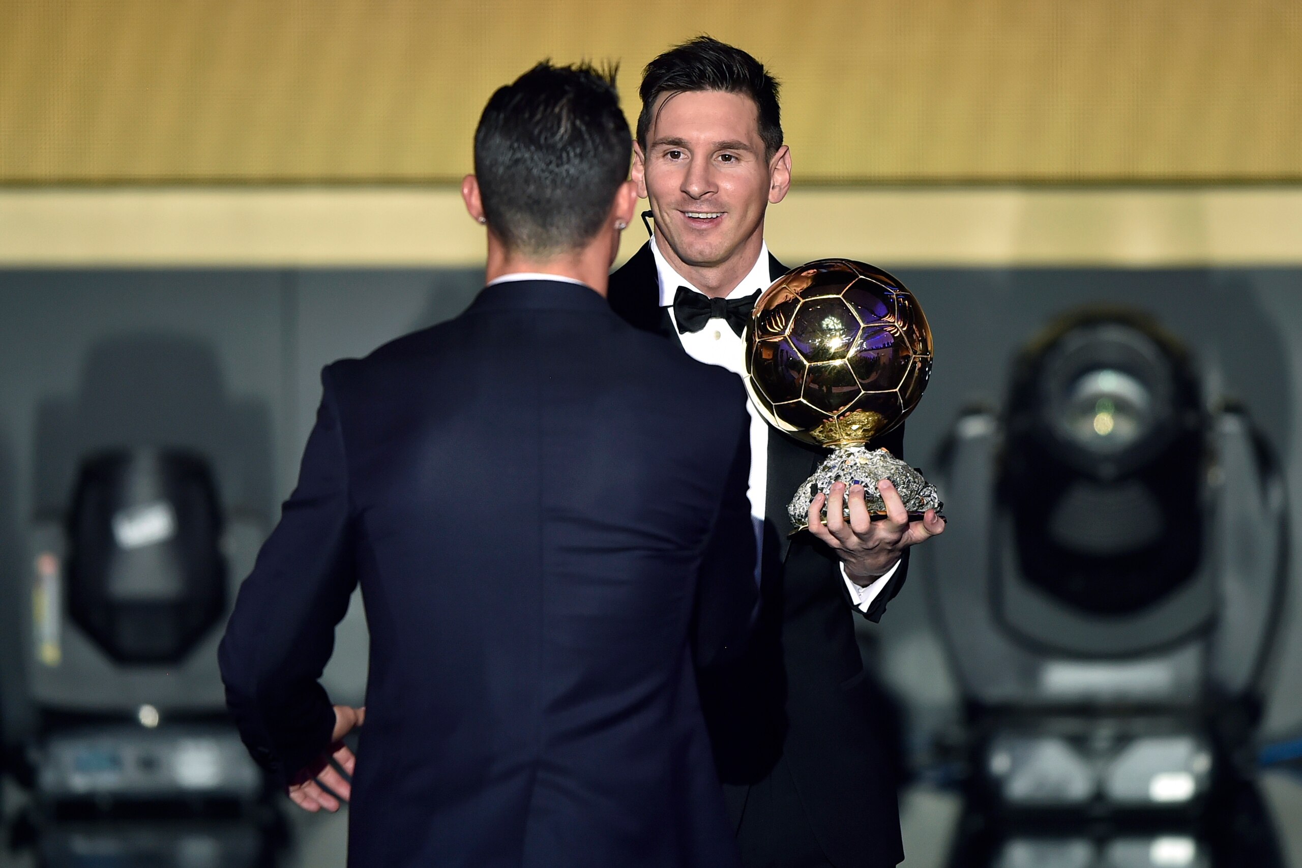 FC Barcelona and Argentina's forward Lionel Messi (R) holds his trophy as he shakes hands with Real Madrid and Portugal's forward  Cristiano Ronaldo after receiving the 2015 FIFA Ballon dOr award for player of the year during the 2015 FIFA Ballon d'Or awa