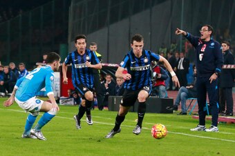 Inter Milan's Croatian midfielder Ivan Perisic (R) fights for the ball with Napoli's Albanian defender Elseid Hysaj as Napoli's Italian coach Maurizio Sarri (R) gestures during the Italian Serie A football match SSC Napoli vs Inter Milan on November 30, 2