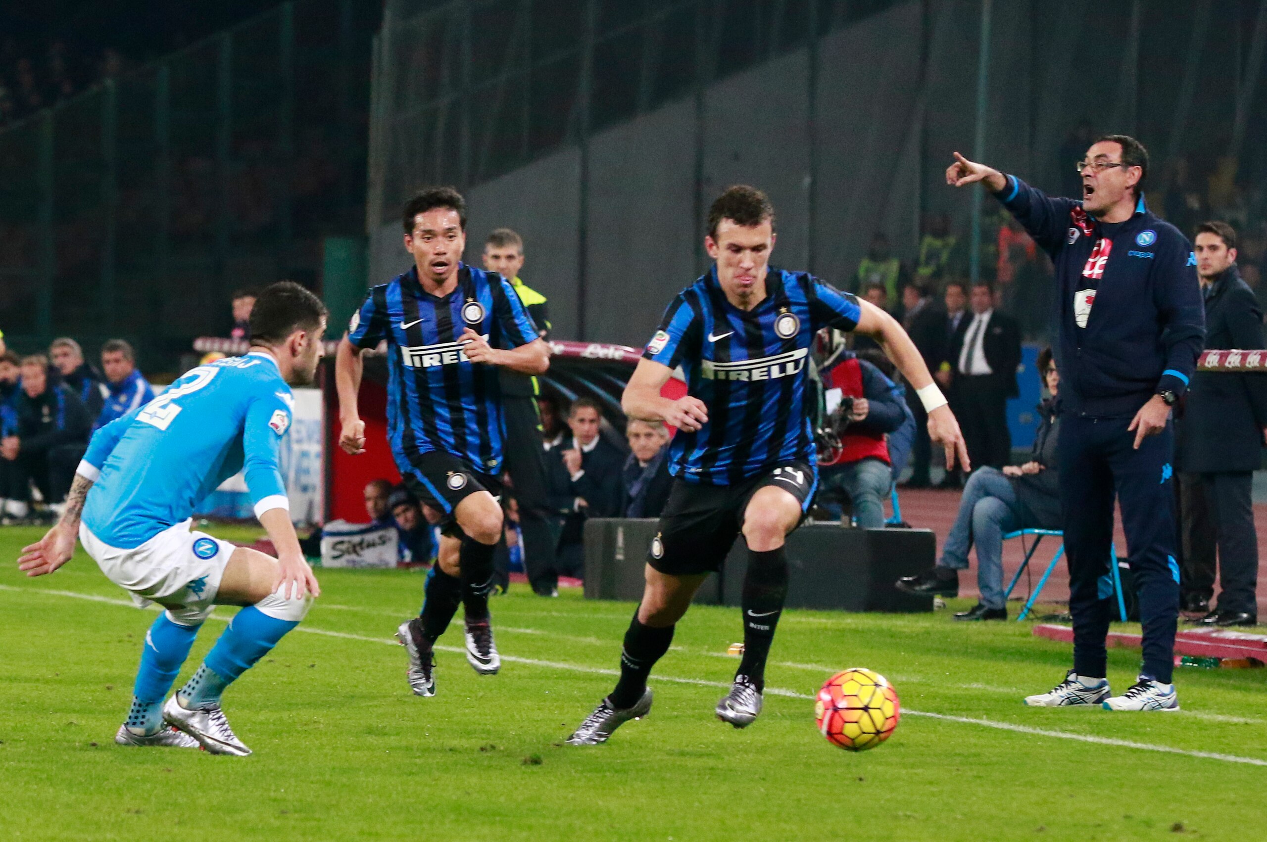 Inter Milan's Croatian midfielder Ivan Perisic (R) fights for the ball with Napoli's Albanian defender Elseid Hysaj as Napoli's Italian coach Maurizio Sarri (R) gestures during the Italian Serie A football match SSC Napoli vs Inter Milan on November 30, 2