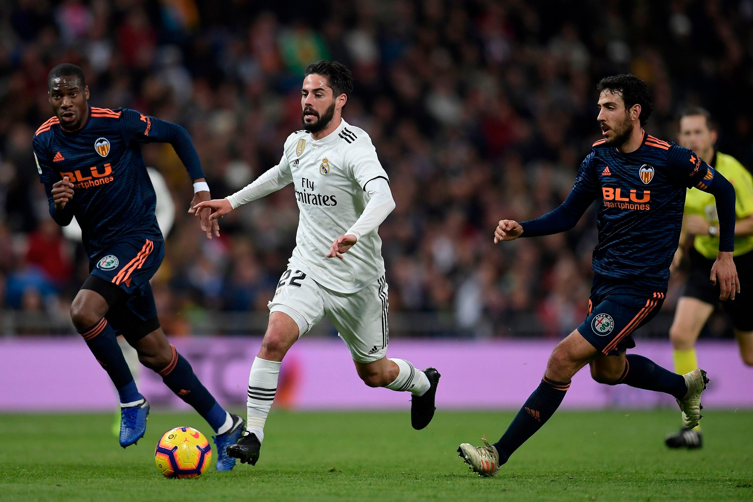 Real Madrid's Spanish midfielder Isco (C) challenges Valencia's Spanish midfielder Daniel Parejo (R) and Valencia's French midfielder Geoffrey Kondogbia during the Spanish league football match between Real Madrid and Valencia at the Santiago Bernabeu sta