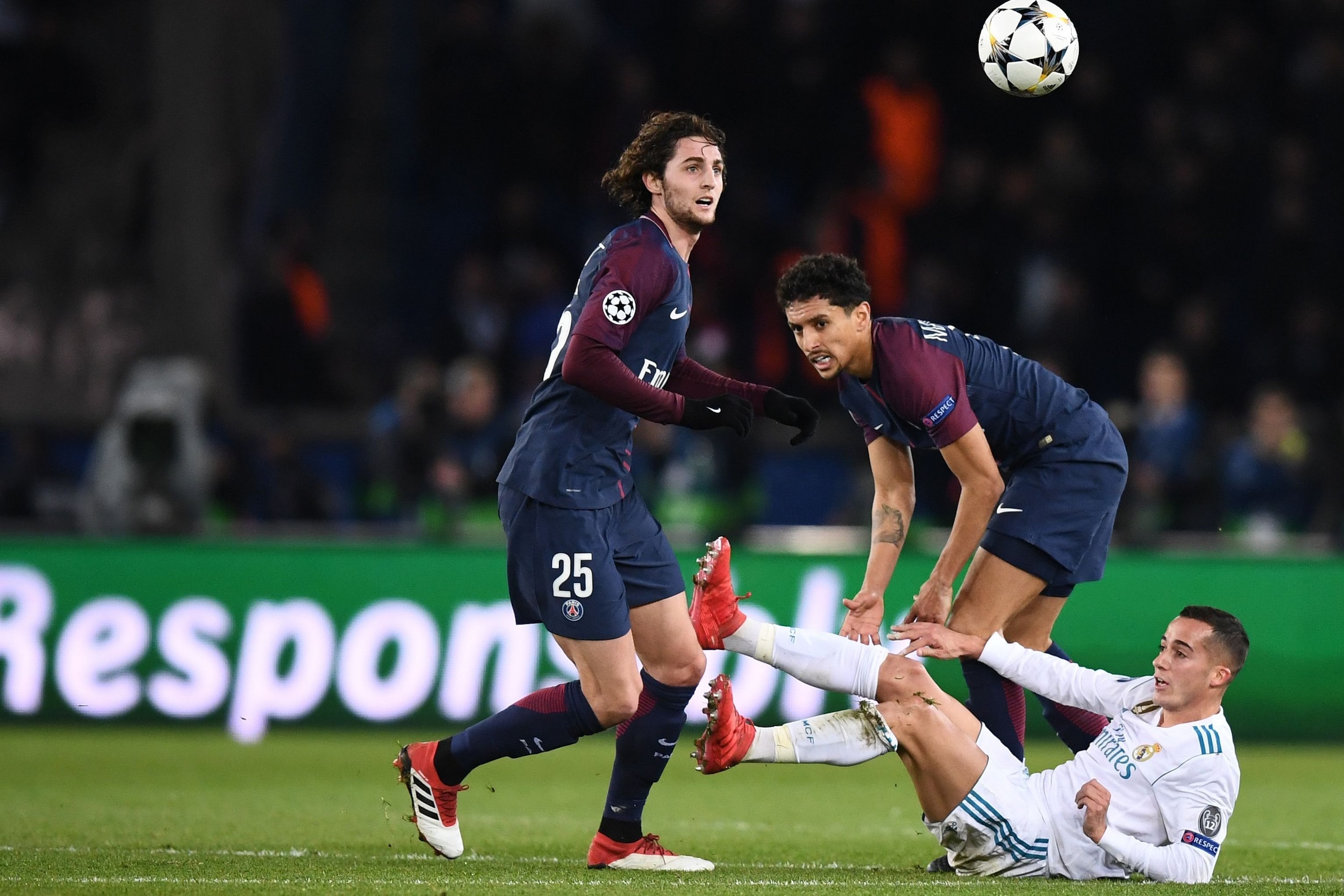 Paris Saint-Germain's French midfielder Adrien Rabiot (L) and Paris Saint-Germain's Brazilian defender Marquinhos (C) vie for the ball with Real Madrid's Spanish midfielder Lucas Vazquez (R)  during the UEFA Champions League round of 16 second leg footbal