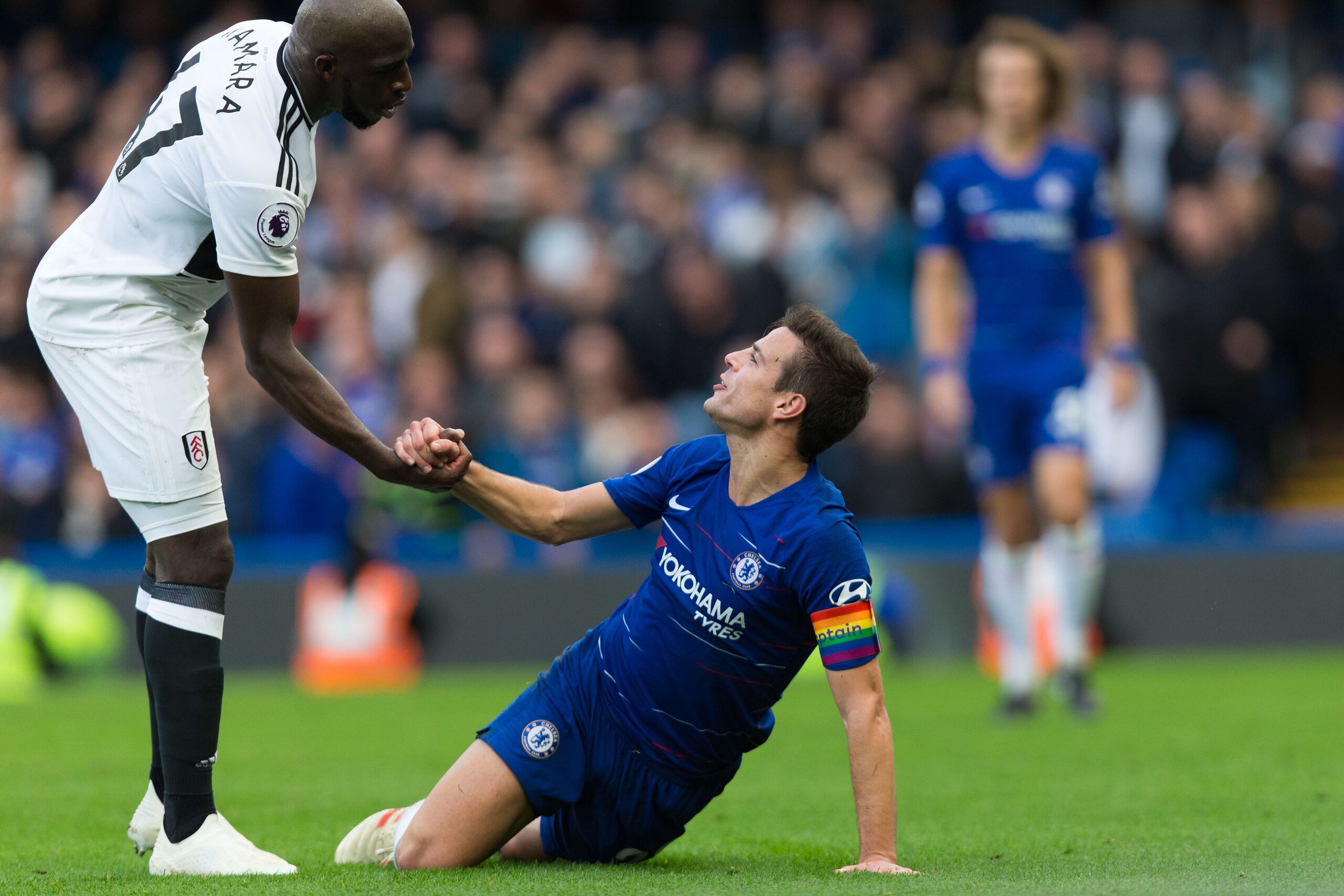 LONDON, ENGLAND - DECEMBER 02: Cesar Azpilicueta of Chelsea is helped up by Aboubakar Kamara of Fulham during the Premier League match between Chelsea FC and Fulham FC at Stamford Bridge on December 2, 2018 in London, United Kingdom. (Photo by Craig Merce