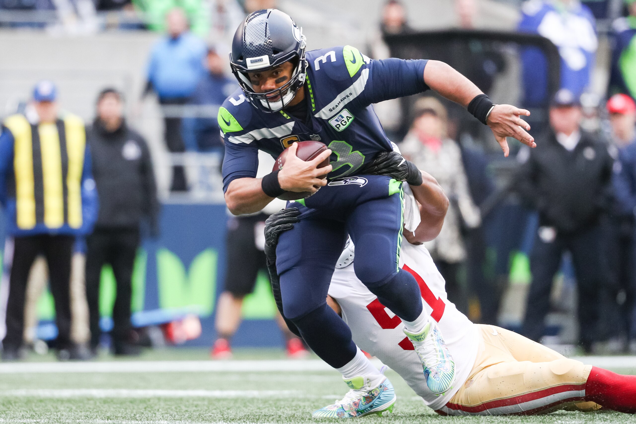 SEATTLE, WA - DECEMBER 02: Russell Wilson #3 of the Seattle Seahawks avoids a tackle by Malcolm Smith #51 of the San Francisco 49ers in the first half at CenturyLink Field on December 2, 2018 in Seattle, Washington. (Photo by Abbie Parr/Getty Images)
