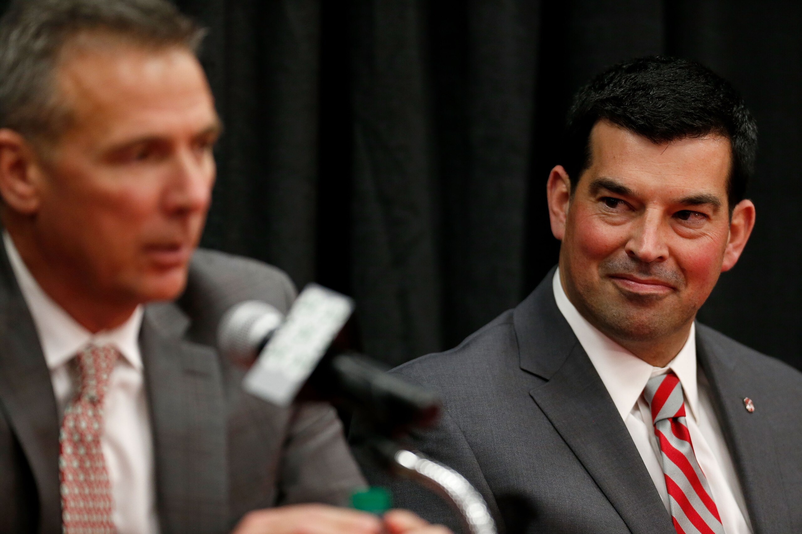 COLUMBUS, OH - DECEMBER 04: Offensive coordinator Ryan Day of the Ohio State Buckeyes listens as head coach Urban Meyer answers a question during a press conference at Ohio State University on December 4, 2018 in Columbus, Ohio. At the press conference M COLUMBUS, OH - DECEMBER 04: Offensive coordinator Ryan Day of the Ohio State Buckeyes listens as head coach Urban Meyer answers a question during a press conference at Ohio State University on December 4, 2018 in Columbus, Ohio. At the press conference M