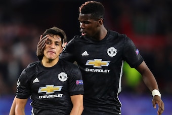 SEVILLE, SPAIN - FEBRUARY 21:  Paul Pogba of Manchester United talks with teammate Alexis Sanchez during the UEFA Champions League Round of 16 First Leg match between Sevilla FC and Manchester United at Estadio Ramon Sanchez Pizjuan on February 21, 2018 i