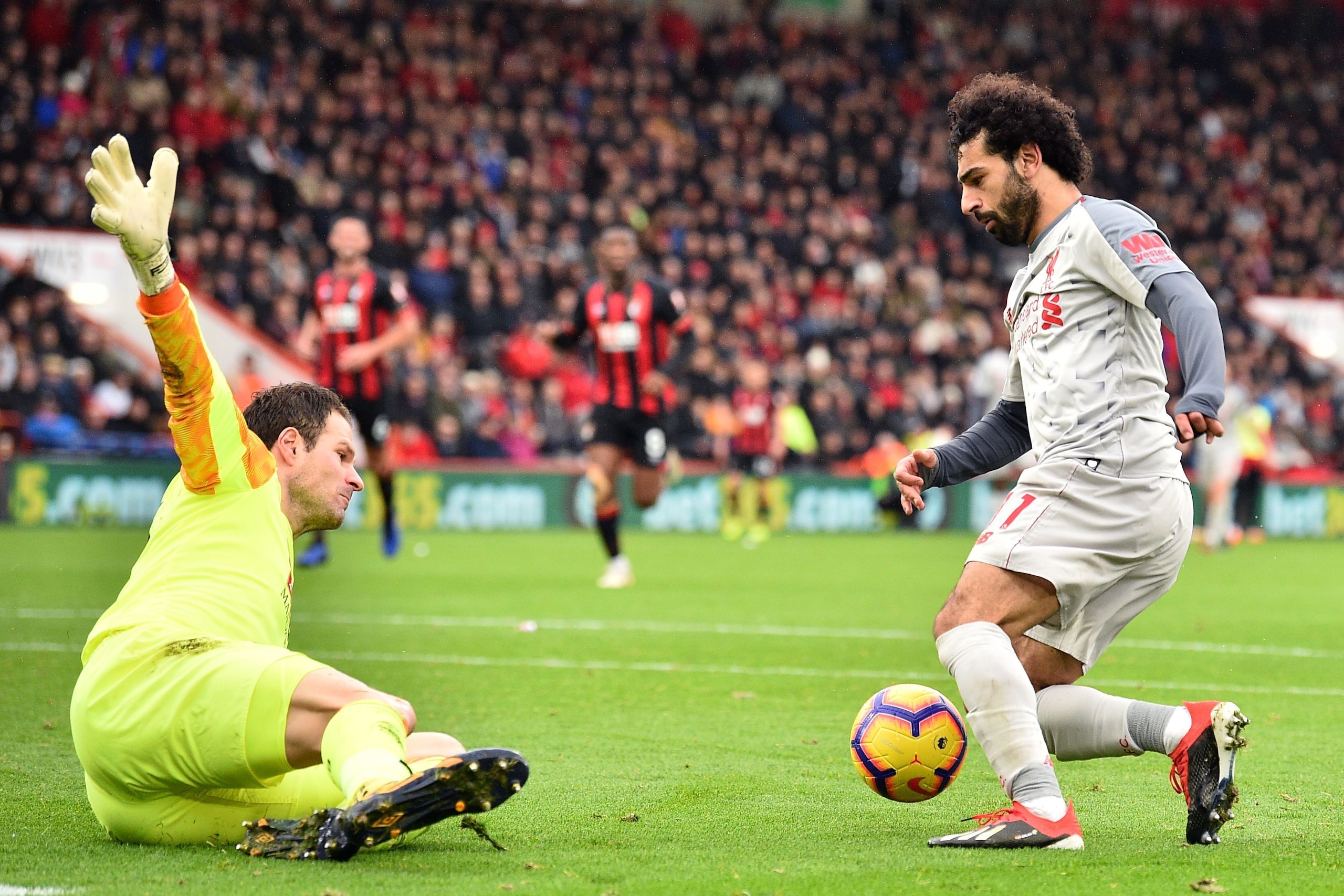 Liverpool's Egyptian midfielder Mohamed Salah (R) takes the ball around Bournemouth's Bosnian-Herzegovinian goalkeeper Asmir Begovic (L0 in the build-up to scoring his third goal, Liverpool's fourth during the English Premier League football match between