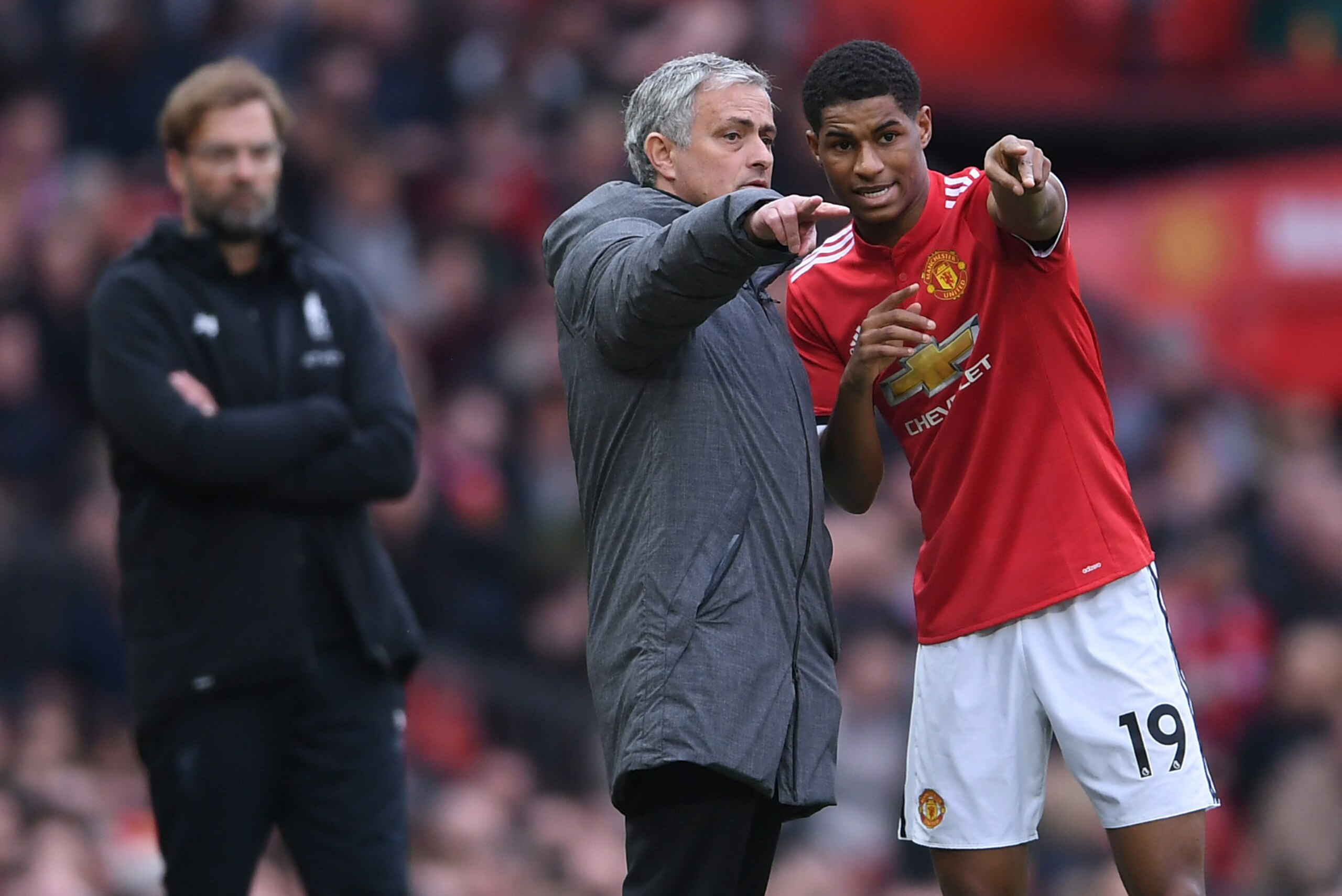 MANCHESTER, ENGLAND - MARCH 10:  Jose Mourinho of Manchester United speaks to Marcus Rashford as Jurgen Klopp of Liverpool looks on during the Premier League match between Manchester United and Liverpool at Old Trafford on March 10, 2018 in Manchester, En