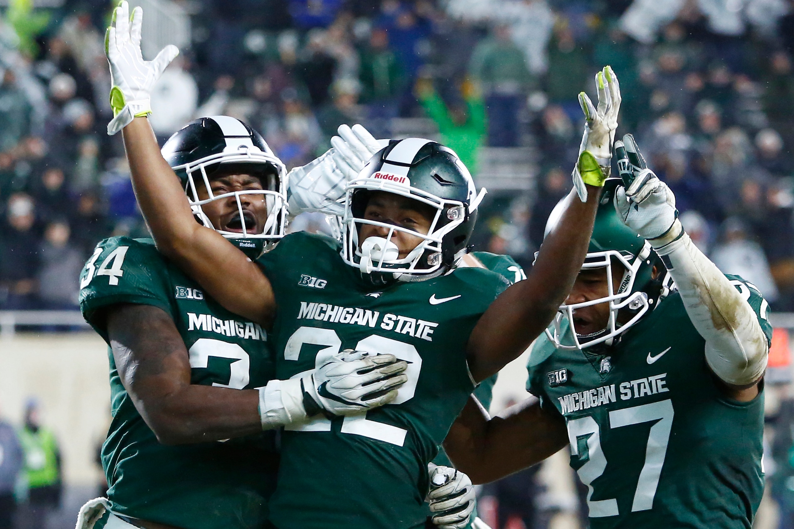 EAST LANSING, MI - NOVEMBER 24:  Cornerback Josiah Scott #22 celebrates with linebacker Antjuan Simmons #34 and safety Khari Willis #27 of the Michigan State Spartans after intercepting a pass by quarterback Giovanni Rescigno #17 of the Rutgers Scarlet Kn