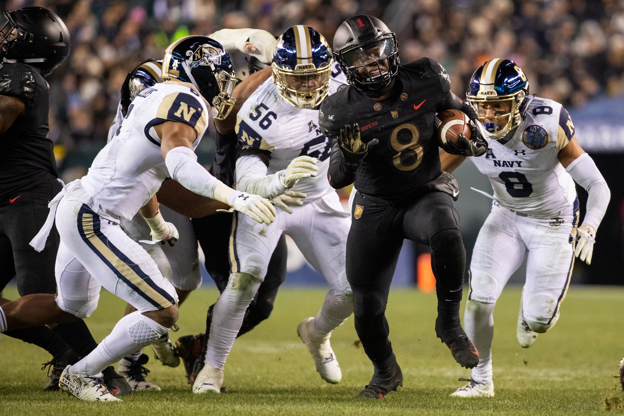 PHILADELPHIA, PA - DECEMBER 08: Kelvin Hopkins Jr. #8 of the Army Black Knights carries the ball before stopped tackled by Elan Nash #8 and Sean Williams #6 of the Navy Midshipmen at Lincoln Financial Field on December 8, 2018 in Philadelphia, Pennsylvani