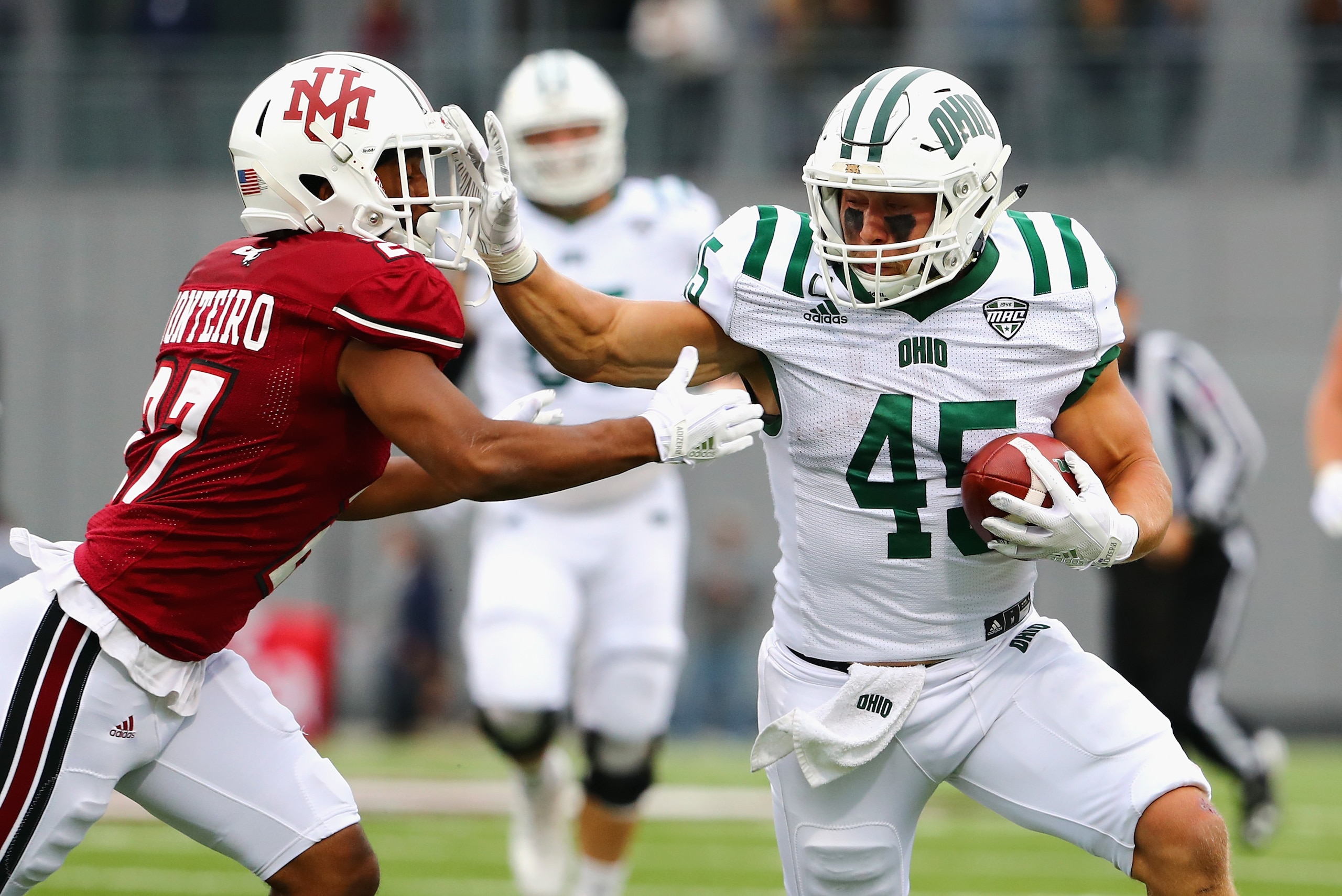 HADLEY, MA - SEPTEMBER 30:  A.J. Ouellette #45 of the Ohio Bobcats stiff arms Jesse Monteiro #27 of the Massachusetts Minutemen during the first half of their game at Warren McGuirk Alumni Stadium on September 30, 2017 in Hadley, Massachusetts.  (Photo by