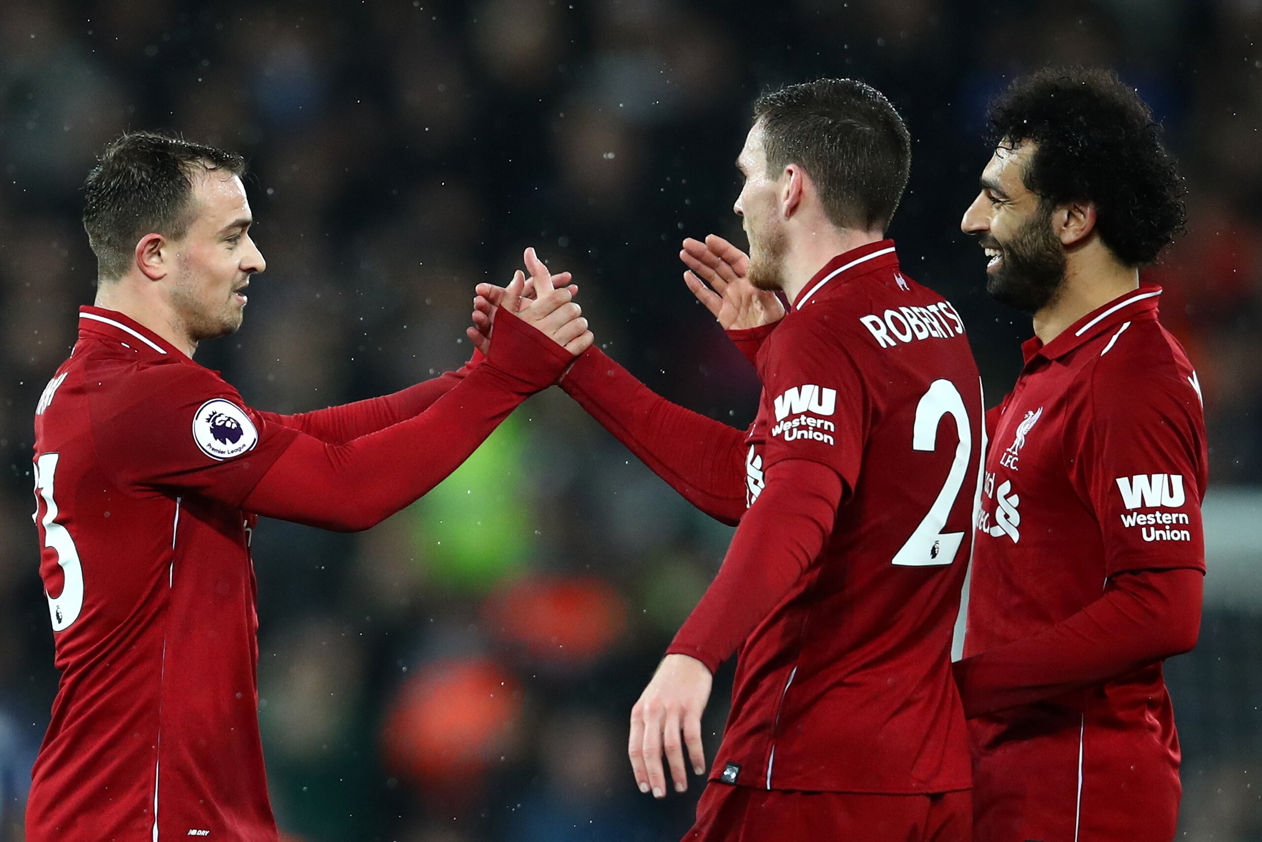LIVERPOOL, ENGLAND - DECEMBER 16:  Xherdan Shaqiri of Liverpool celebrates with team mates Andy Robertson and Mohamed Salah of Liverpool following their side's victory in the Premier League match between Liverpool FC and Manchester United at Anfield on De
