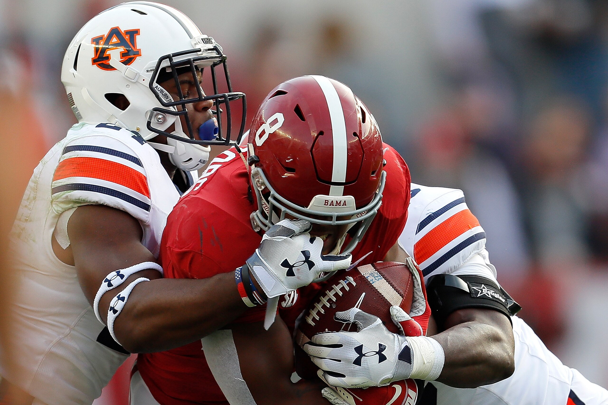 TUSCALOOSA, AL - NOVEMBER 24:  Josh Jacobs #8 of the Alabama Crimson Tide draws a facemask penalty as he is tackled by Daniel Thomas #24 and Montavious Atkinson #48 of the Auburn Tigers at Bryant-Denny Stadium on November 24, 2018 in Tuscaloosa, Alabama. 