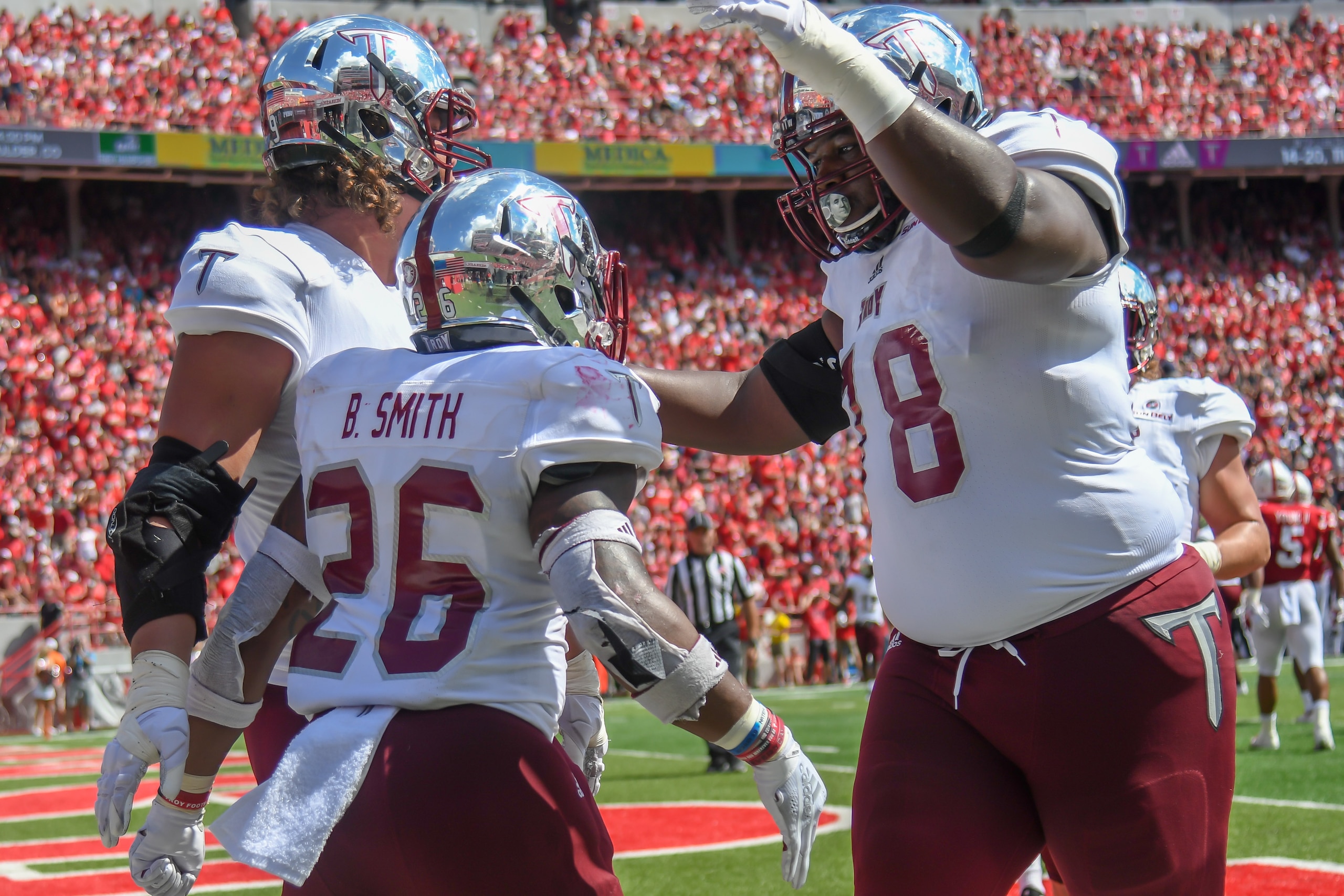 LINCOLN, NE - SEPTEMBER 15: Offensive lineman Jake Andrews #55 of the Troy Trojans and running back B.J. Smith #26 and offensive lineman Kirk Kelley #78 celebrate a touchdown in the second half at Memorial Stadium on September 15, 2018 in Lincoln, Nebrask LINCOLN, NE - SEPTEMBER 15: Offensive lineman Jake Andrews #55 of the Troy Trojans and running back B.J. Smith #26 and offensive lineman Kirk Kelley #78 celebrate a touchdown in the second half at Memorial Stadium on September 15, 2018 in Lincoln, Nebrask