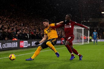 WOLVERHAMPTON, ENGLAND - DECEMBER 21:  Matt Doherty of Wolves holds off pressure from Naby Keita of Liverpool during the Premier League match between Wolverhampton Wanderers and Liverpool FC at Molineux on December 22, 2018 in Wolverhampton, United Kingdo