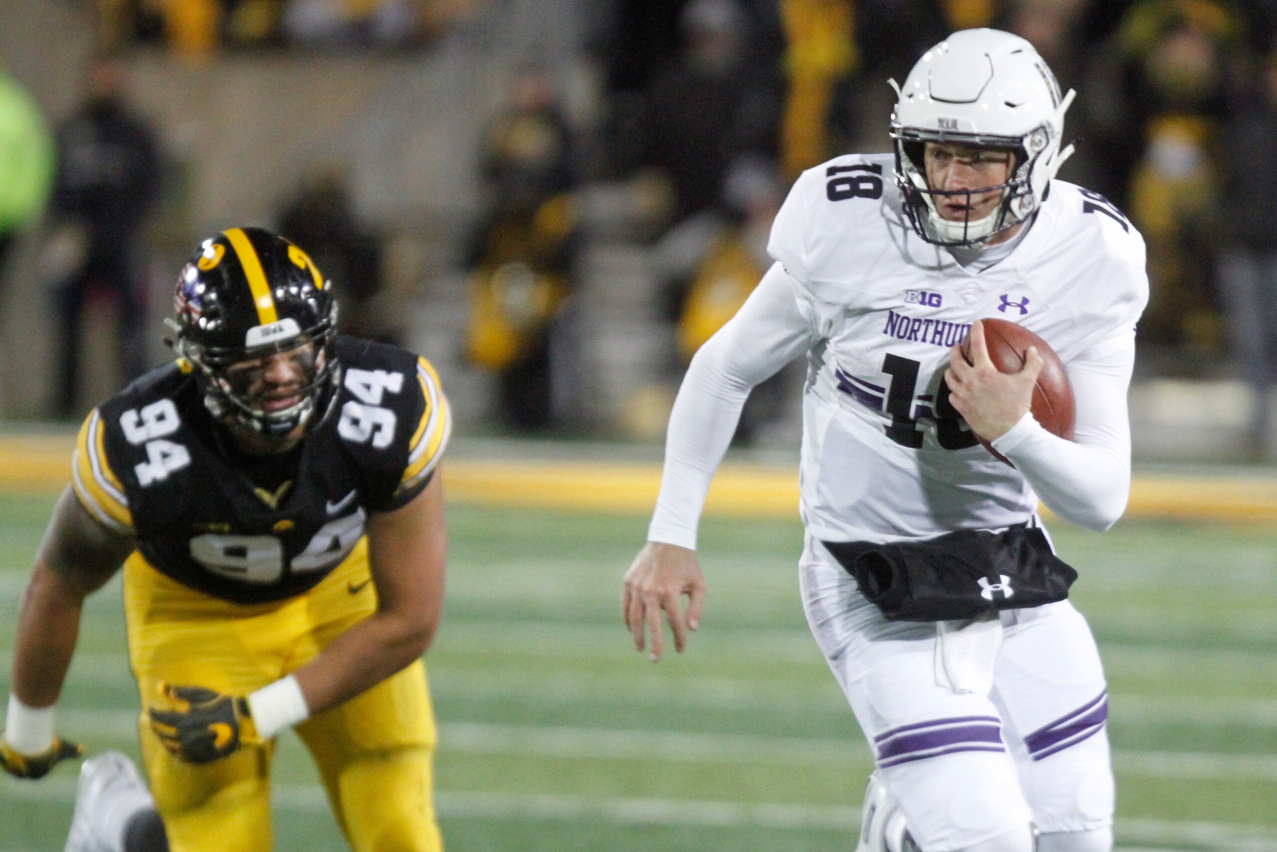 IOWA CITY, IOWA - NOVEMBER 10:  Quarterback Clayton Thorson #18 of the Northwestern Wildcats breaks a tackle in the second half from defensive end A.J. Epenesa #94 of the Iowa Hawkeyes, on November 10, 2018 at Kinnick Stadium, in Iowa City, Iowa.  (Photo 