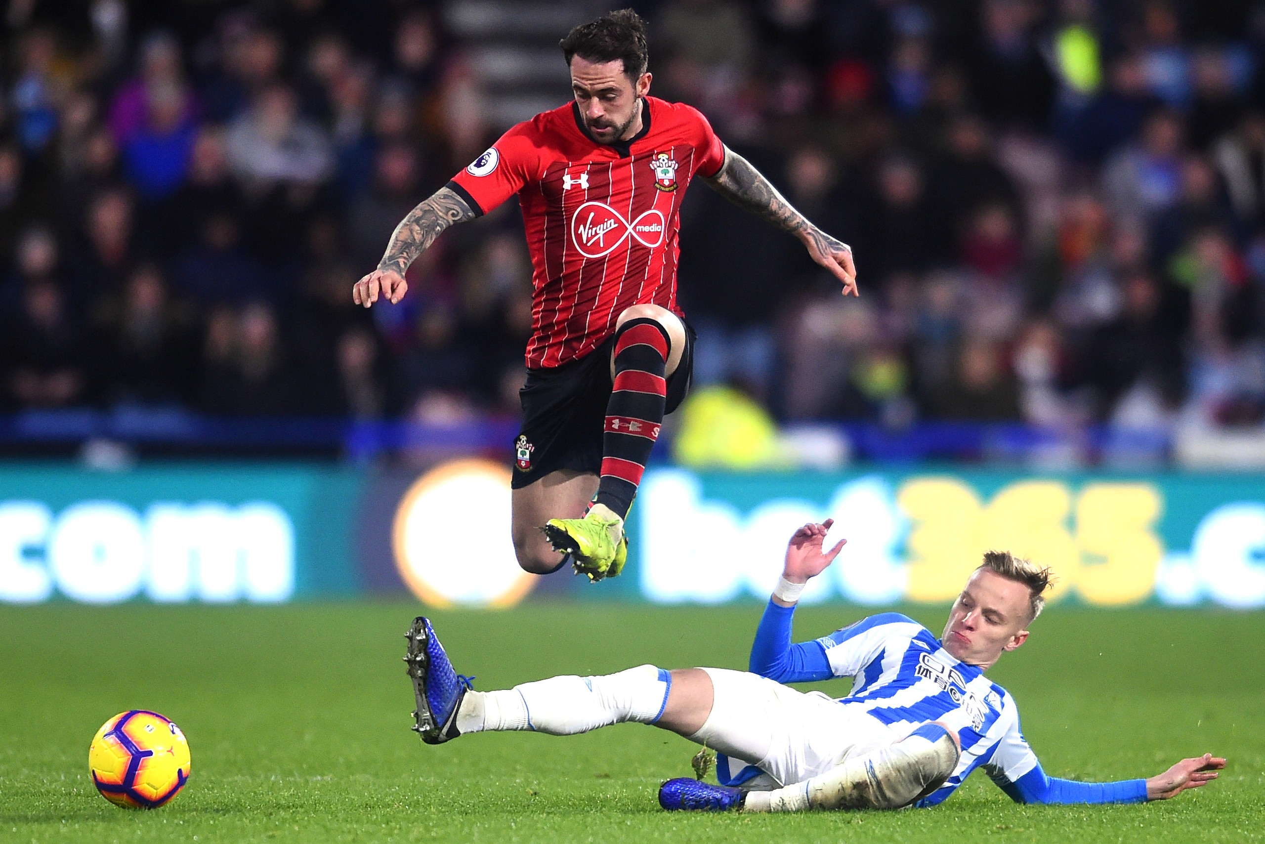HUDDERSFIELD, ENGLAND - DECEMBER 22:  Danny Ings of Southampton jumps over a challenge from Florent Hadergjonaj of Huddersfield Town during the Premier League match between Huddersfield Town and Southampton FC at John Smith's Stadium on December 22, 2018 