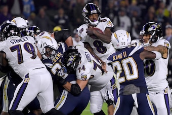CARSON, CALIFORNIA - DECEMBER 22:   Lamar Jackson #8 of the Baltimore Ravens extends the ball on his keeper for a first down during the first quarter against the Los Angeles Chargers at StubHub Center on December 22, 2018 in Carson, California. (Photo by 