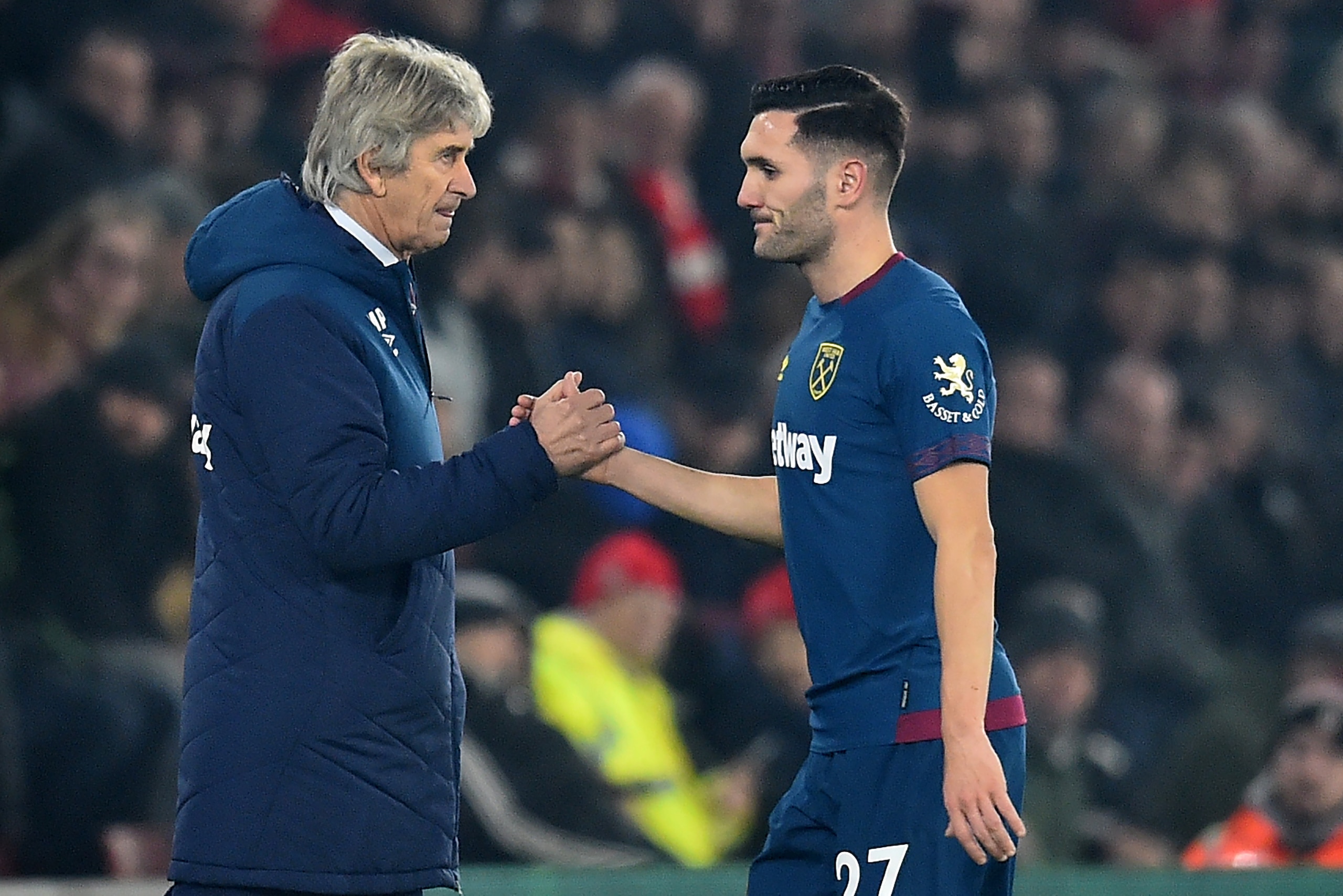 West Ham United's Spanish striker Lucas Perez (R) shakes hands with West Ham United's Chilean manager Manuel Pellegrini (L) as he leaves the pitch substituted during the English Premier League football match between Southampton and West Ham United at St M