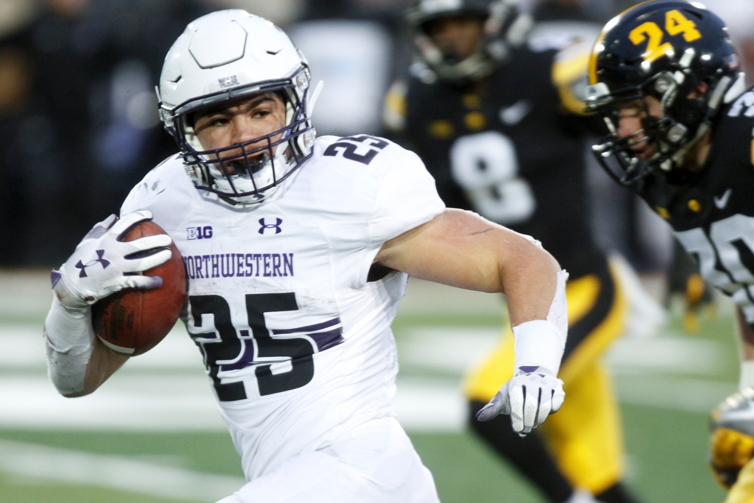 IOWA CITY, IOWA - NOVEMBER 10:  Running back Isaiah Bowser #25 of the Northwestern Wildcats breaks away on a touchdown run in the second half in front of defensive back Jake Gervase #30 of the Iowa Hawkeyes, on November 10, 2018 at Kinnick Stadium, in Iow