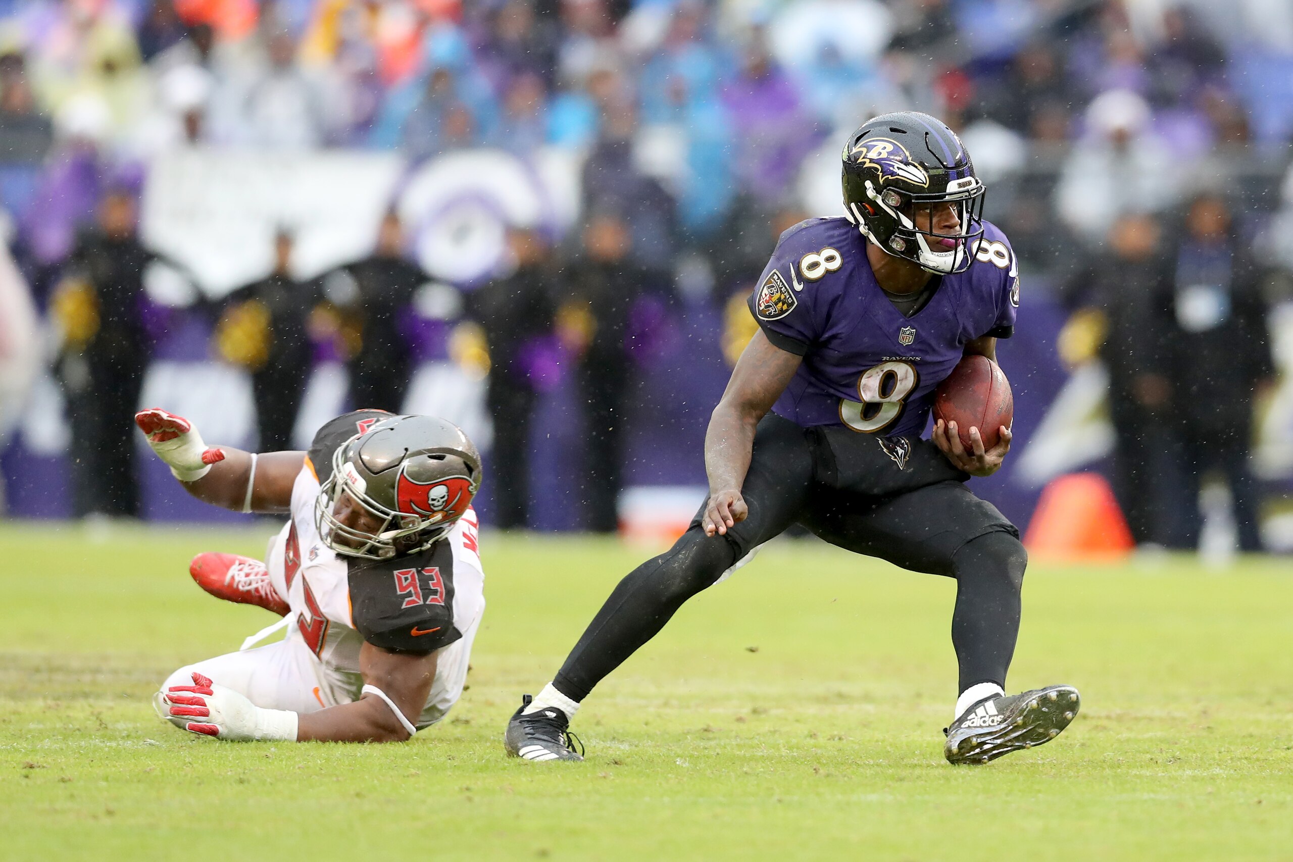 BALTIMORE, MARYLAND - DECEMBER 16: Quarterback Lamar Jackson #8 of the Baltimore Ravens runs in front of Gerald McCoy #93 of the Tampa Bay Buccaneers in the second half at M&T Bank Stadium on December 16, 2018 in Baltimore, Maryland. (Photo by Rob Carr/Ge