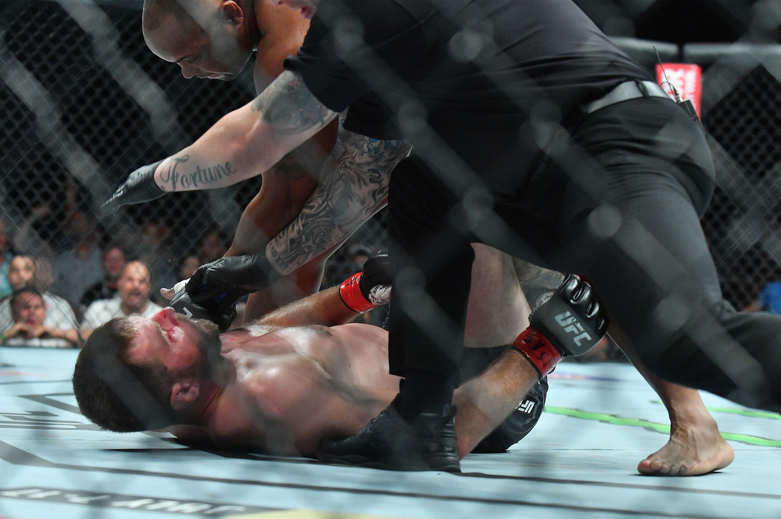 LAS VEGAS, NV - JULY 07:  Daniel Cormier (top) punches Stipe Miocic as referee Marc Goddard intervenes to stop  their heavyweight championship fight at T-Mobile Arena on July 7, 2018 in Las Vegas, Nevada. Cormier won by first round knockout.  (Photo by Sa