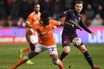 Blackpool's Ivory Coast striker Armand Gnanduillet (L) goes down in a challenge with Arsenal's Welsh midfielder Aaron Ramsey (R) during the English FA Cup third round football match between Blackpool and Arsenal at Bloomfield Road in Blackpool, north west Blackpool's Ivory Coast striker Armand Gnanduillet (L) goes down in a challenge with Arsenal's Welsh midfielder Aaron Ramsey (R) during the English FA Cup third round football match between Blackpool and Arsenal at Bloomfield Road in Blackpool, north west
