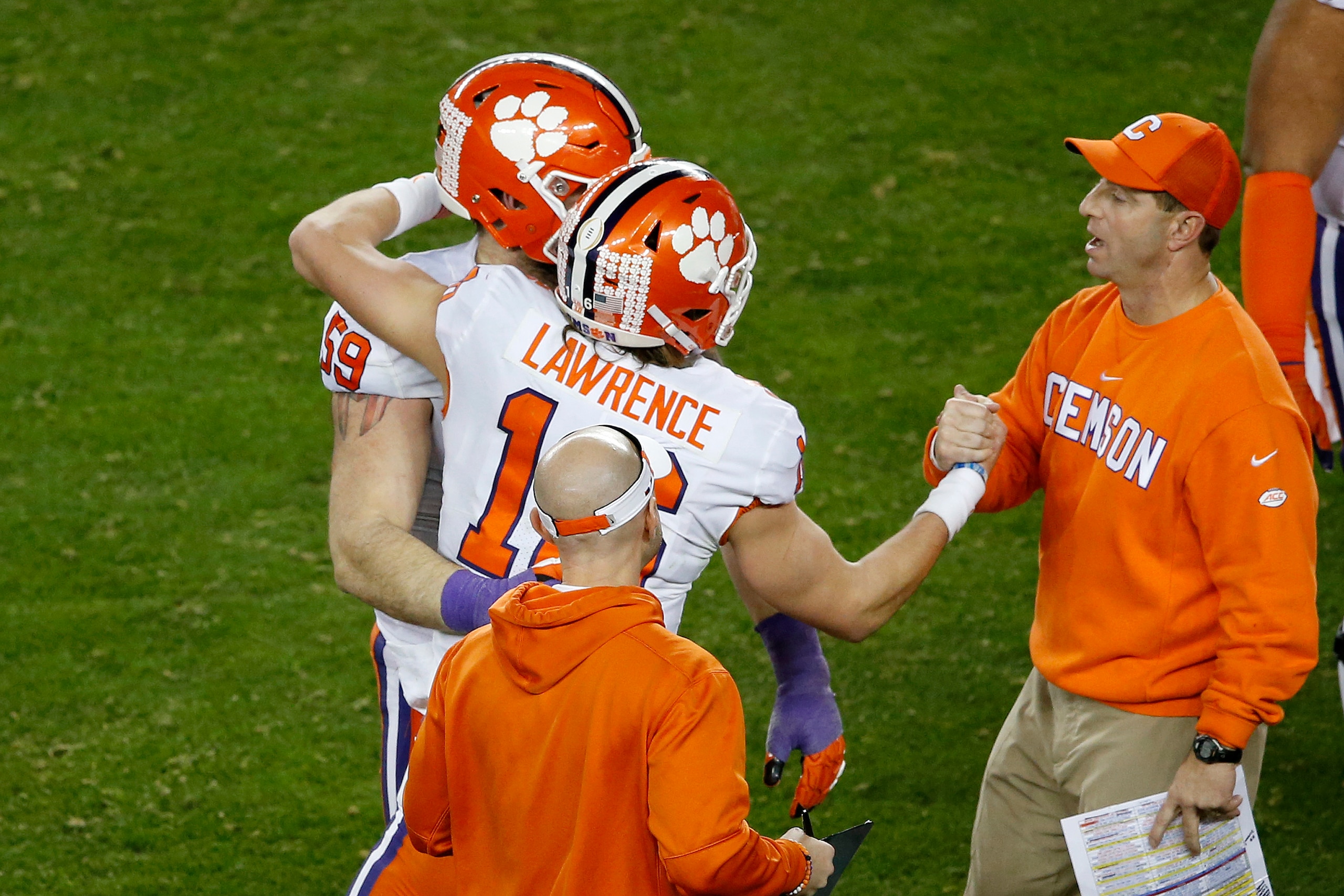 SANTA CLARA, CALIFORNIA - JANUARY 07: Trevor Lawrence #16 of the Clemson Tigers celebrates with head coach Dabo Swinney against the Alabama Crimson Tide during the fourth quarter in the College Football Playoff National Championship at Levi's Stadium on J