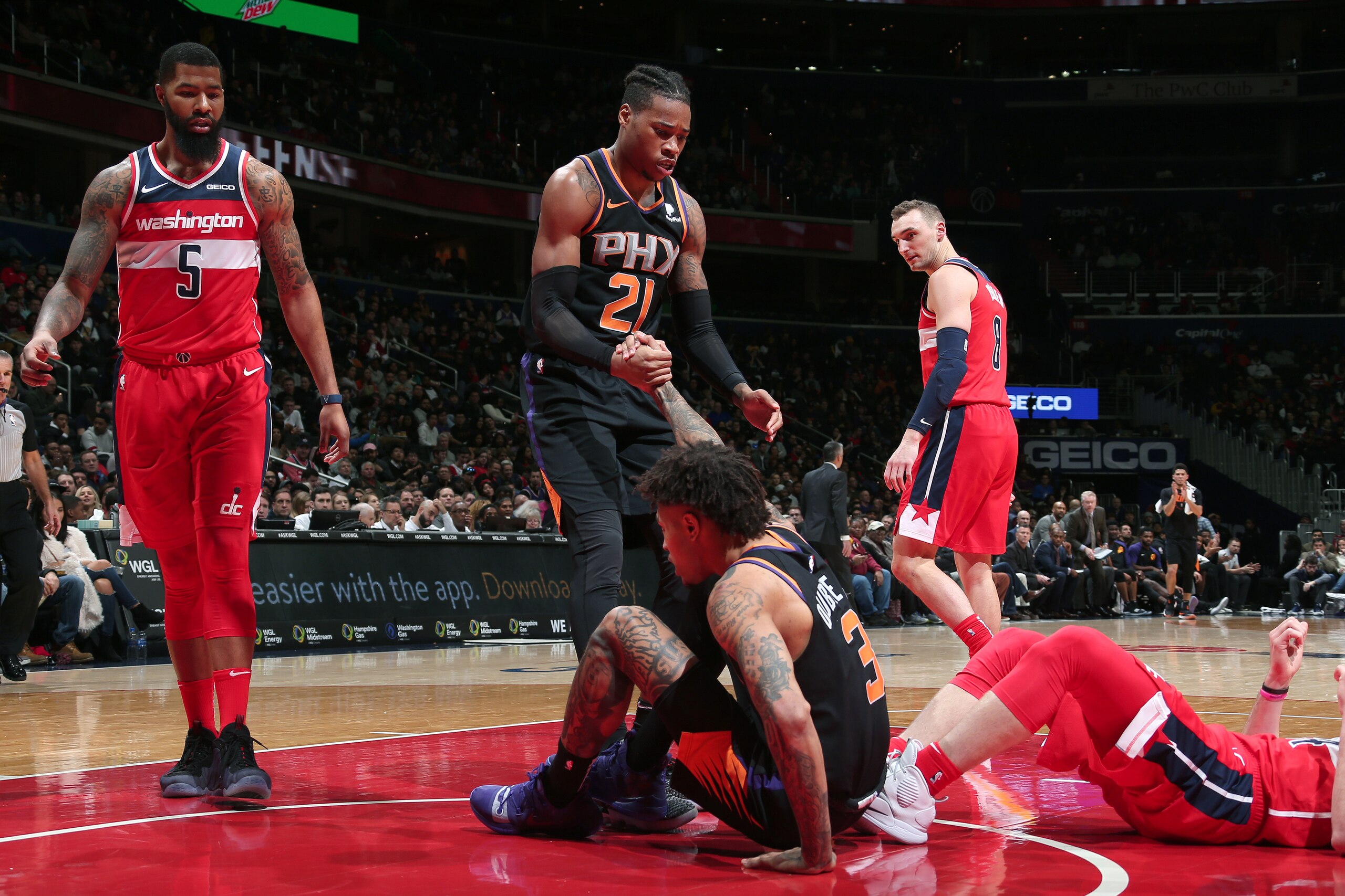 WASHINGTON, DC - DECEMBER 22: Richaun Holmes #21 helps up Kelly Oubre Jr. #3 of the Phoenix Suns during the game against the Washington Wizards on December 22, 2018 at Capital One Arena in Washington, DC. NOTE TO USER: User expressly acknowledges and agre