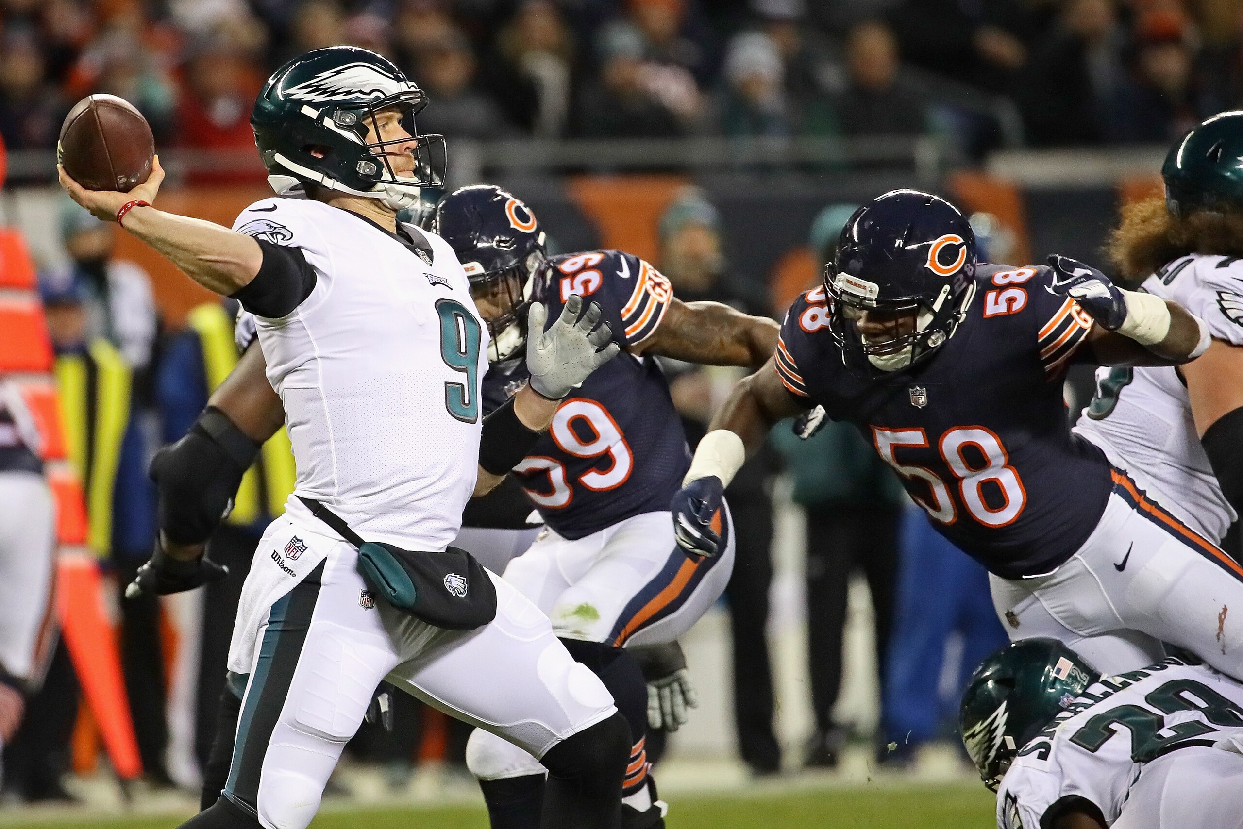 CHICAGO, IL - JANUARY 06:  Nick Foles #9 of the Philadelphia Eagles passes under pressure from Khalil Mack #52 of the Chicago Bears during an NFC Wild Card playoff game at Soldier Field on January 6, 2019 in Chicago, Illinois. The Eagles defeated the Bear