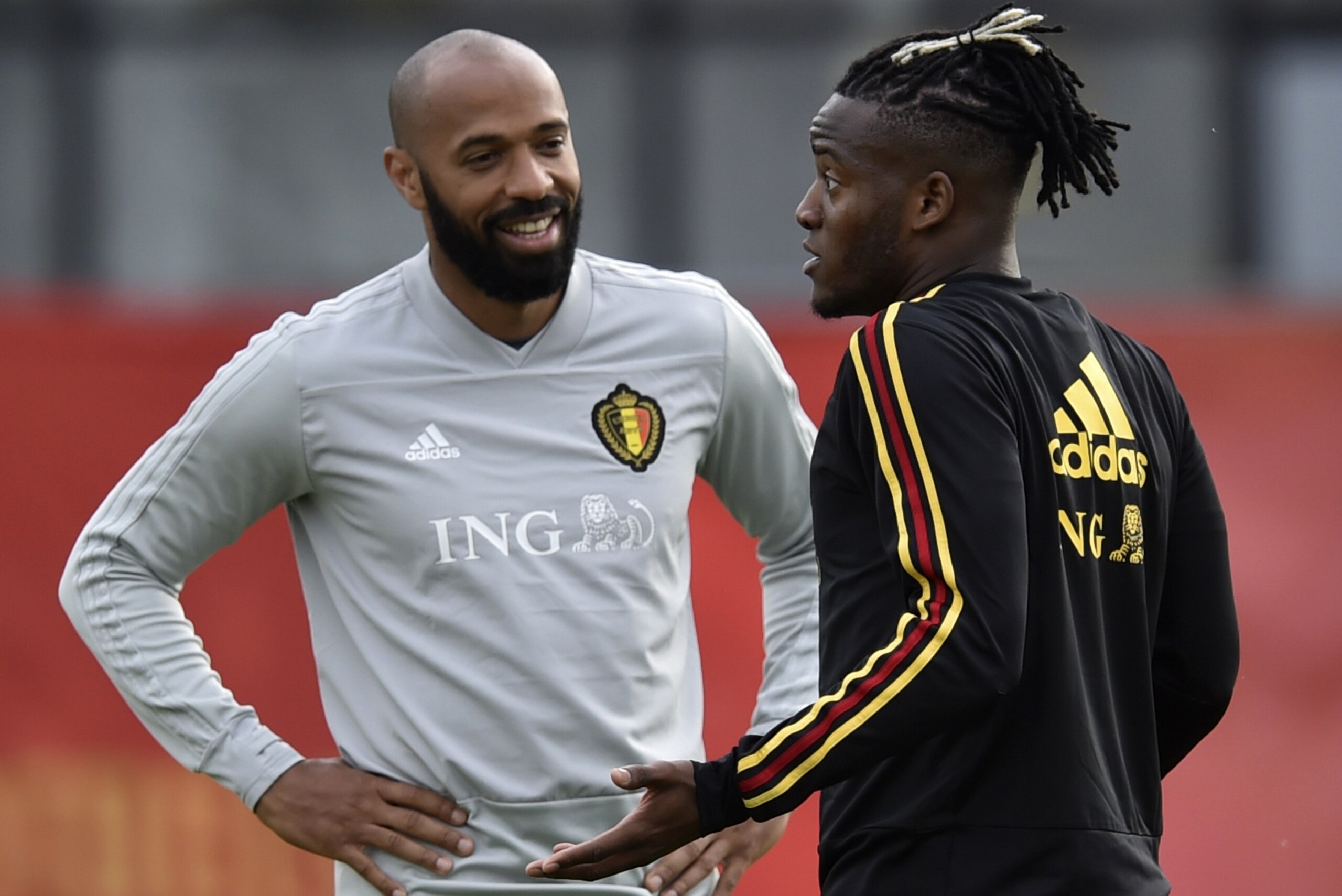 Belgium's forward Michy Batshuayi (R) speaks with coach assistan French Thierry Daniel Henry (L) as they take part in a training session at the Dedovsk stadium in Moscow on June 14, 2018 during the Russia 2018 football World Cup. (Photo by YURI CORTEZ / A