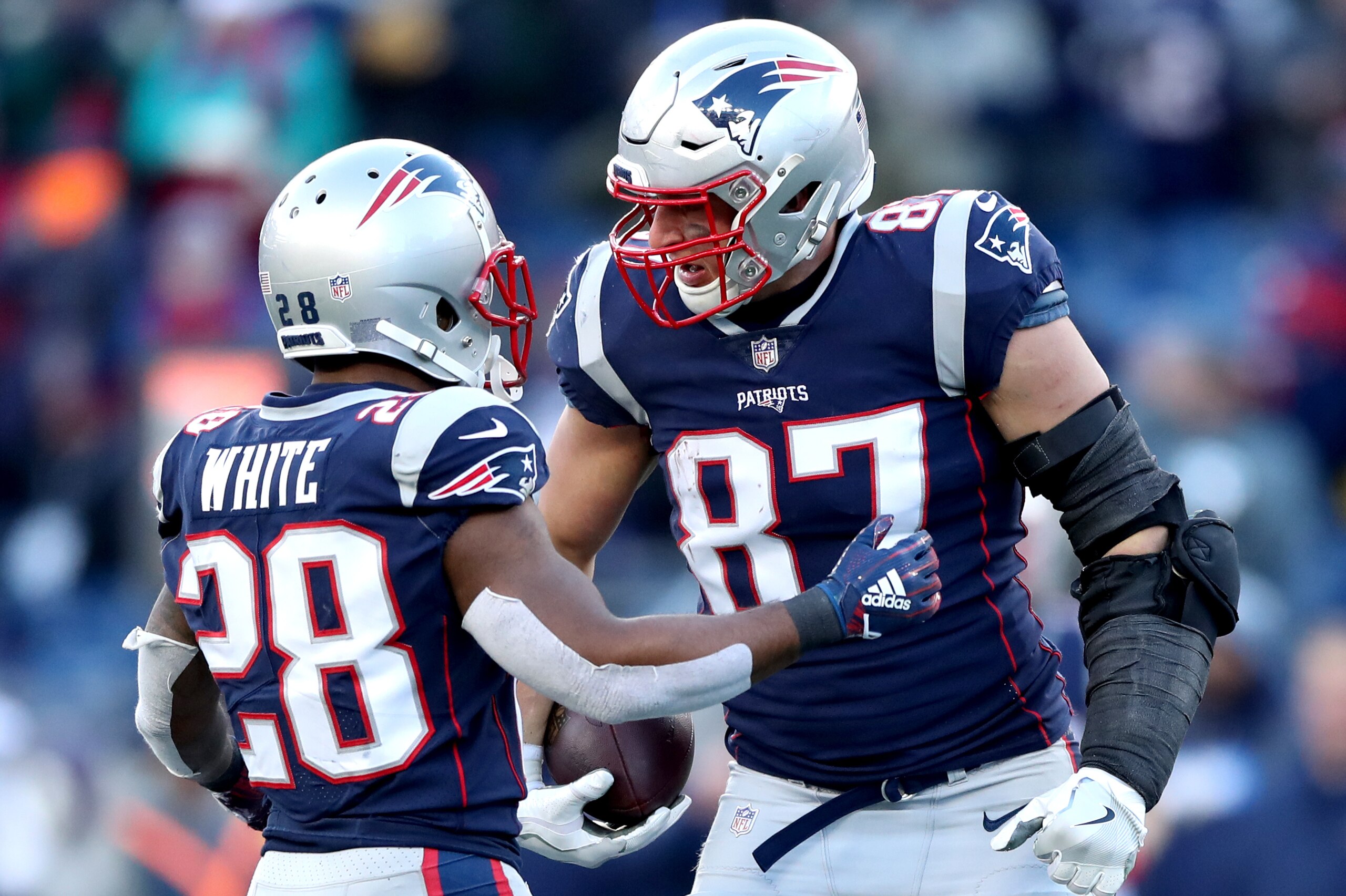 FOXBOROUGH, MASSACHUSETTS - JANUARY 13: James White #28 of the New England Patriots reacts with Rob Gronkowski #87 during the third quarter in the AFC Divisional Playoff Game against the Los Angeles Chargers at Gillette Stadium on January 13, 2019 in Foxb