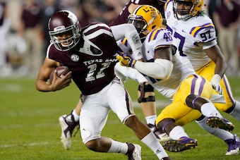 White (R) tackles Texas A&M quarterback Kellen Mond.