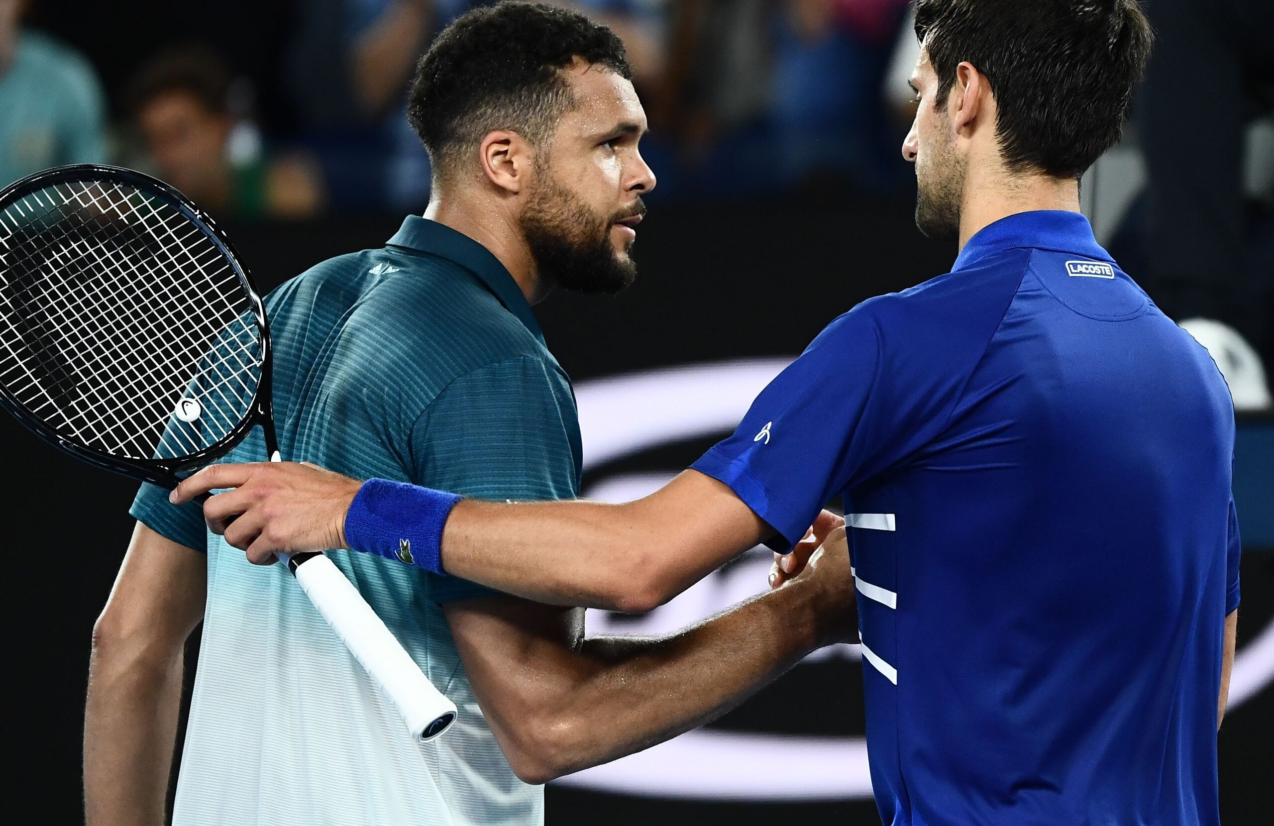 Serbia's Novak Djokovic (L) shakes hands with France's Jo-Wilfried Tsonga after winning their men's singles match on day four of the Australian Open tennis tournament in Melbourne early January 18, 2019. (Photo by Jewel SAMAD / AFP) / -- IMAGE RESTRICTED 