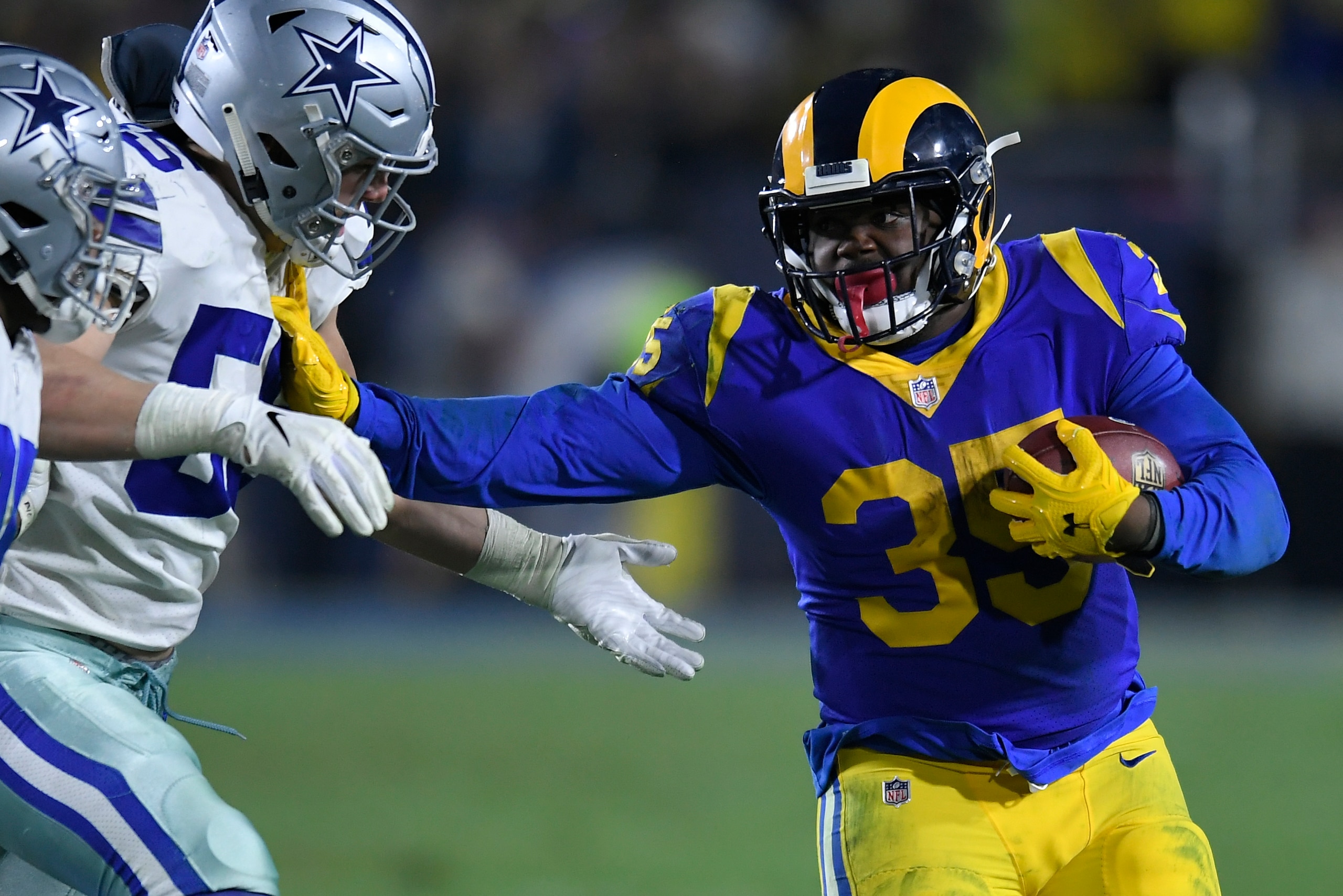 LOS ANGELES, CA - JANUARY 12: Los Angeles Rams running back C.J. Anderson #35 stiff arms Dallas Cowboys outside linebacker Leighton Vander Esch #55 at Los Angeles Memorial Coliseum on January 12, 2019 in Los Angeles, California. (Photo by John McCoy/Getty