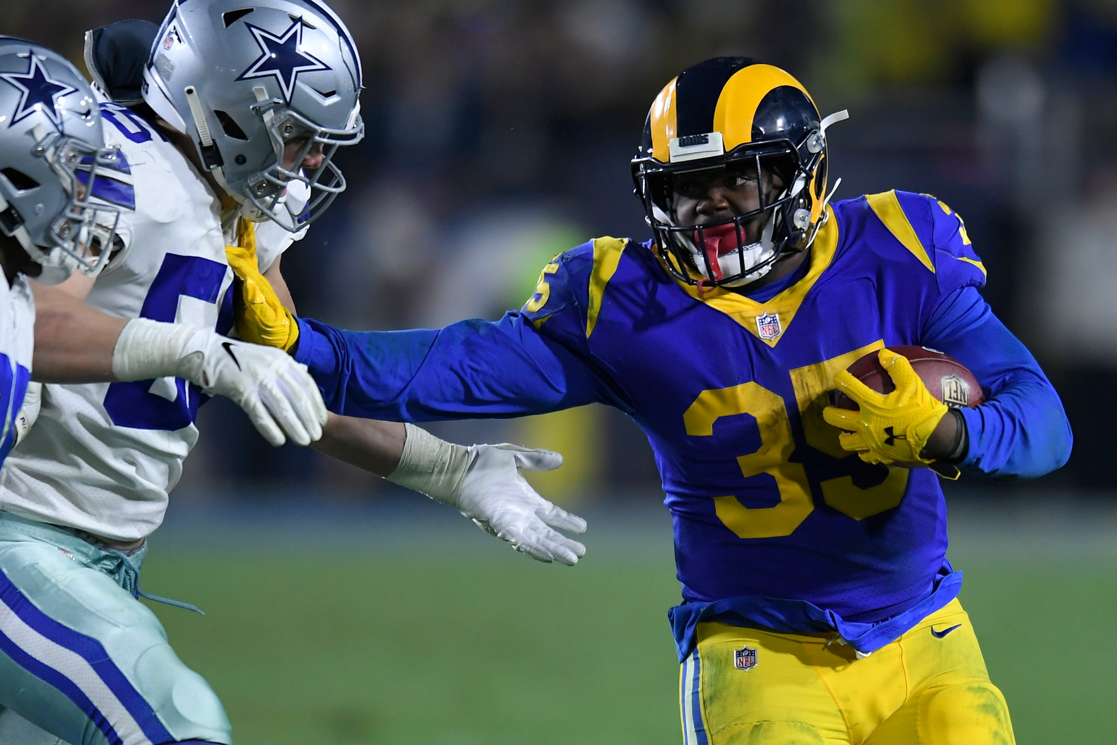 LOS ANGELES, CA - JANUARY 12: Los Angeles Rams running back C.J. Anderson #35 stiff arms Dallas Cowboys outside linebacker Leighton Vander Esch #55 at Los Angeles Memorial Coliseum on January 12, 2019 in Los Angeles, California. (Photo by John McCoy/Getty LOS ANGELES, CA - JANUARY 12: Los Angeles Rams running back C.J. Anderson #35 stiff arms Dallas Cowboys outside linebacker Leighton Vander Esch #55 at Los Angeles Memorial Coliseum on January 12, 2019 in Los Angeles, California. (Photo by John McCoy/Getty