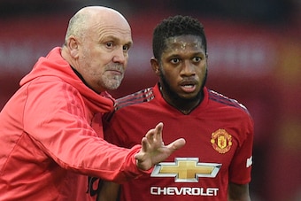Manchester United's English first-team coach Mike Phelan (L) talks to Manchester United's Brazilian midfielder Fred (R) on the touchline during the English Premier League football match between Manchester United and Huddersfield Town at Old Trafford in Ma